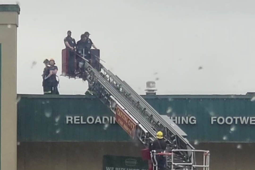 A Capital City Fire/Rescue truck bucket lowers Vance R. Webster III from the roof of Nugget Mall after being detained by Juneau Police Department Sunday morning. (Courtesy / Nano Brooks)