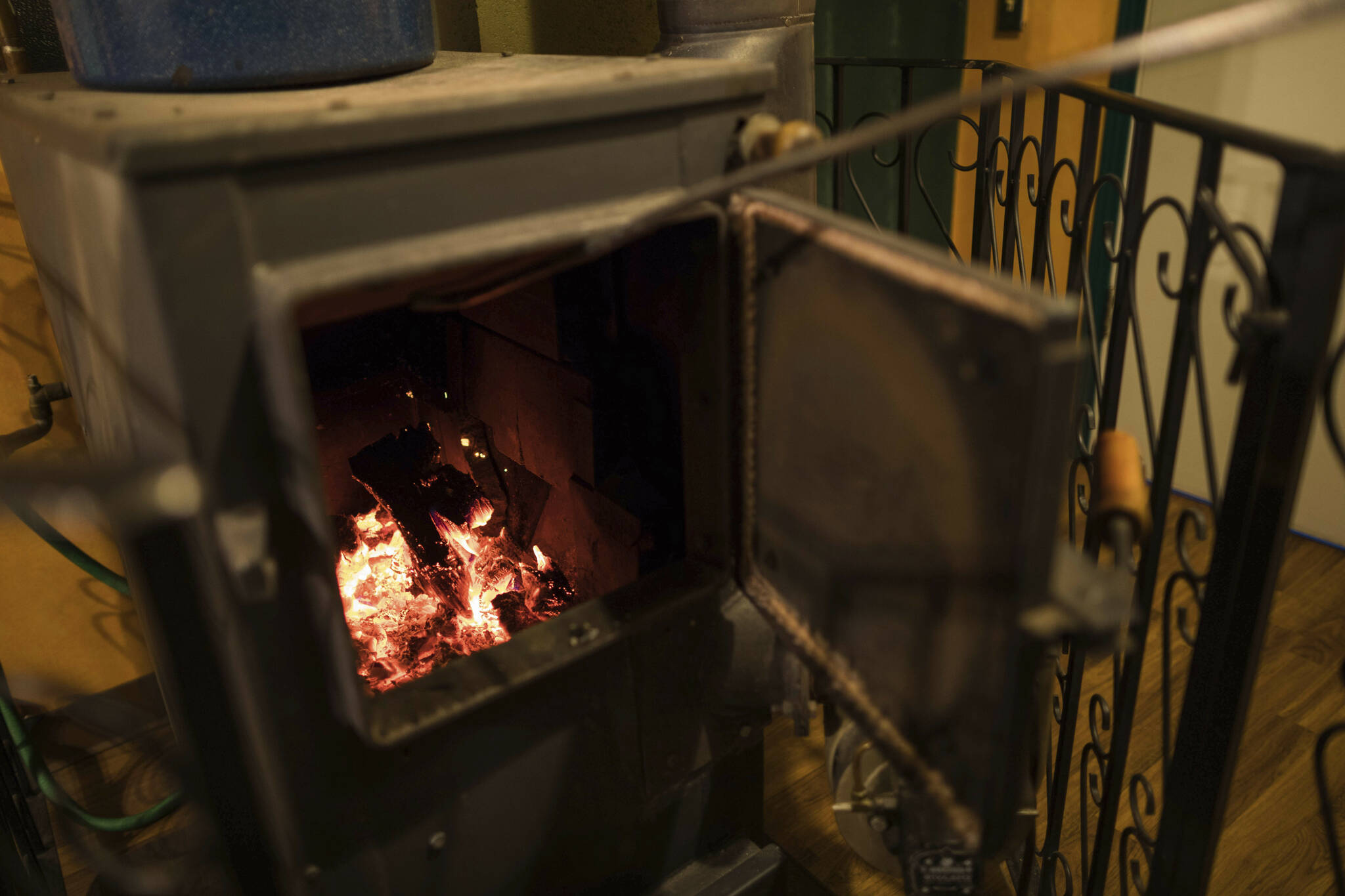 Don Sakis checks the fire in his Riteway wood stove at his home on Jan. 23, 2018, in Palmer. Sakis and his family have heated their home with the stove for 35 years. Attorneys general from 10 states plan to sue the U.S. Environmental Protection Agency, alleging the agency’s testing and certification program for home wood heaters is ineffective — raising health concerns — and that EPA has failed to undertake a timely review of performance standards for new heaters. (Loren Holmes/Anchorage Daily News via AP)