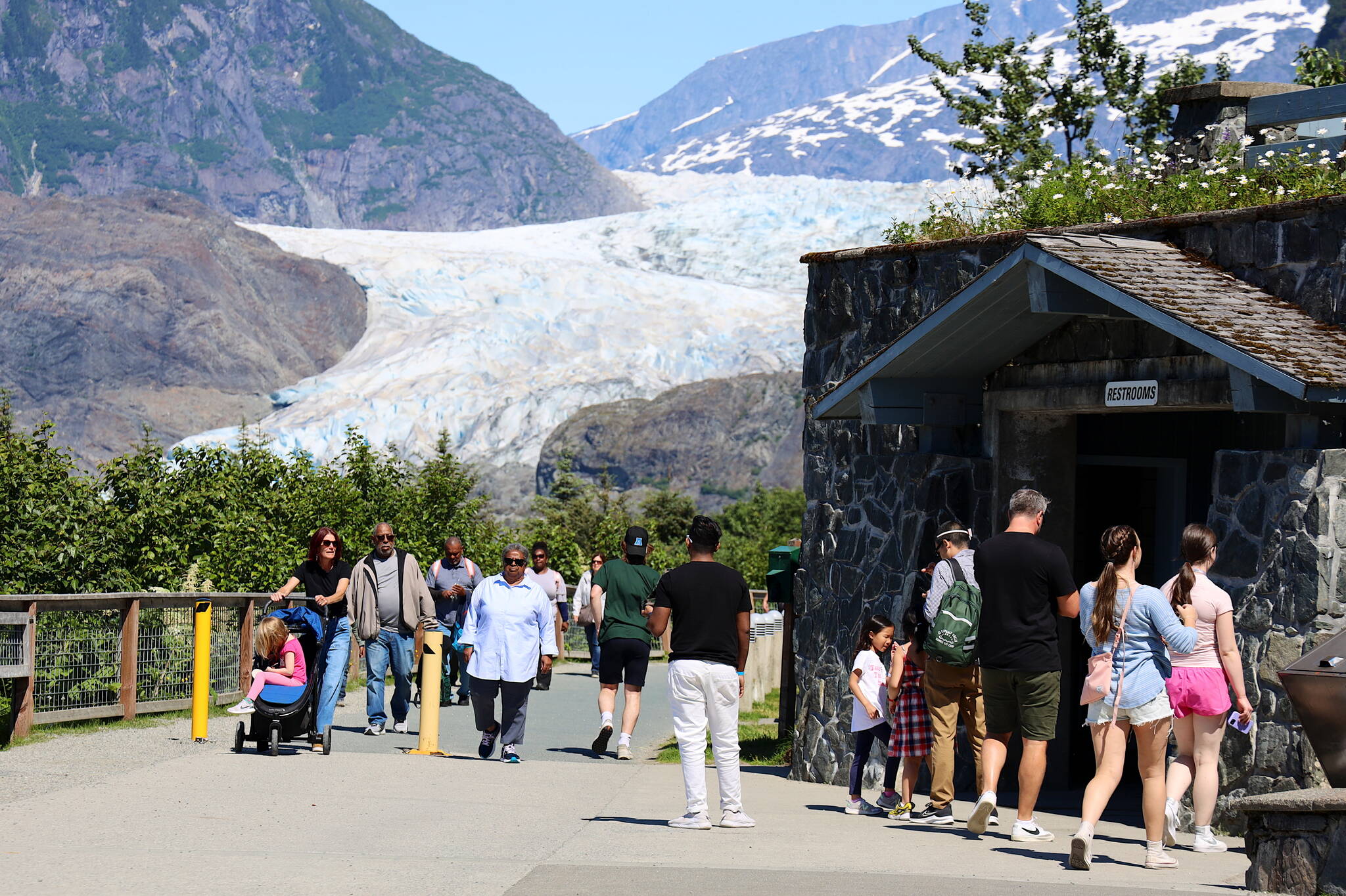 A crowd of visitors tours the Mendenhall Glacier on Friday. Officials announced Friday limits on commercial tours are being imposed as capacity limits are being rapidly reached, which will impact the second half of the summer tourism season. A plan by the U.S. Forest Service to overhaul the facilities of the Mendenhall Glacier Recreation Area is now in the final stage, which would replace the existing capacity limits with newly defined management practices. (Clarise Larson / Juneau Empire)