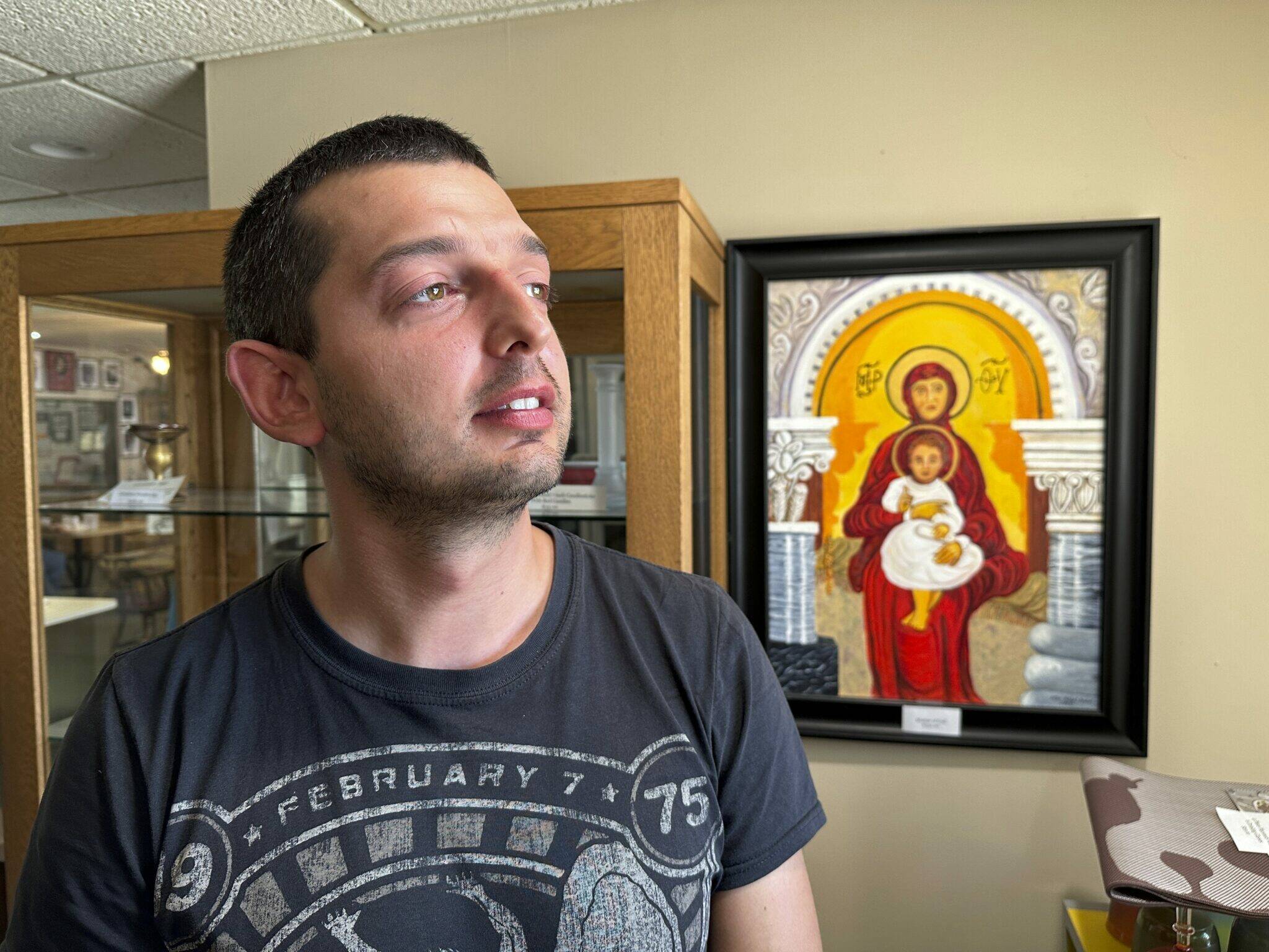 Dmytro Haiman looks out the window from the Ukrainian Cultural Institute in Dickinson, N.D., on Monday, July 17, 2023. Haiman is one of several Ukrainians who are part of a pilot effort of the North Dakota Petroleum Council’s Bakken Global Recruitment of Oilfield Workers program. Haiman is from Chernihiv, Ukraine. (AP Photo/Jack Dura)