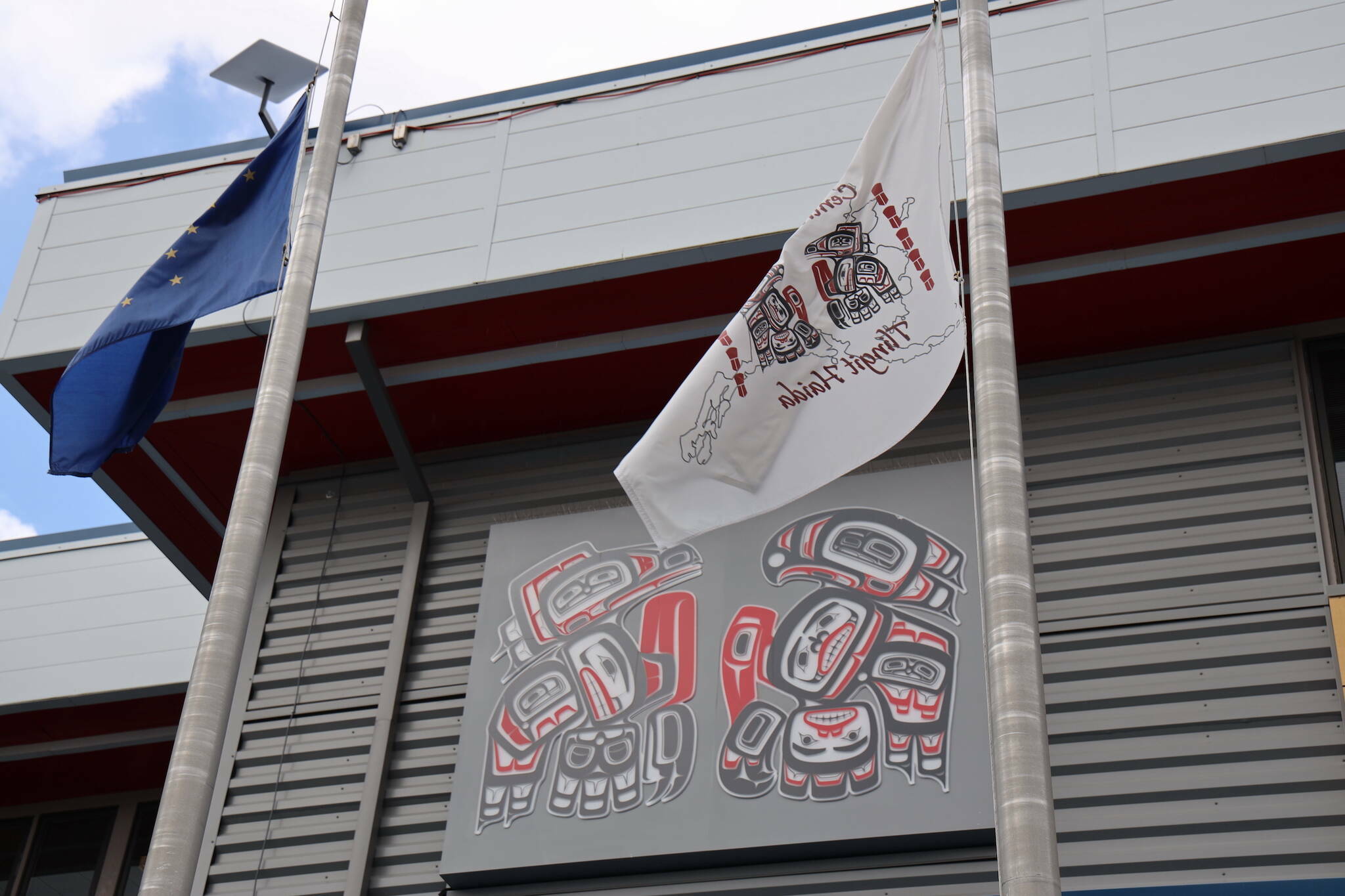 A breeze lifts flags hanging outside of the Andrew Hope Building in downtown Juneau on May 8. (Clarise Larson / Juneau Empire File)