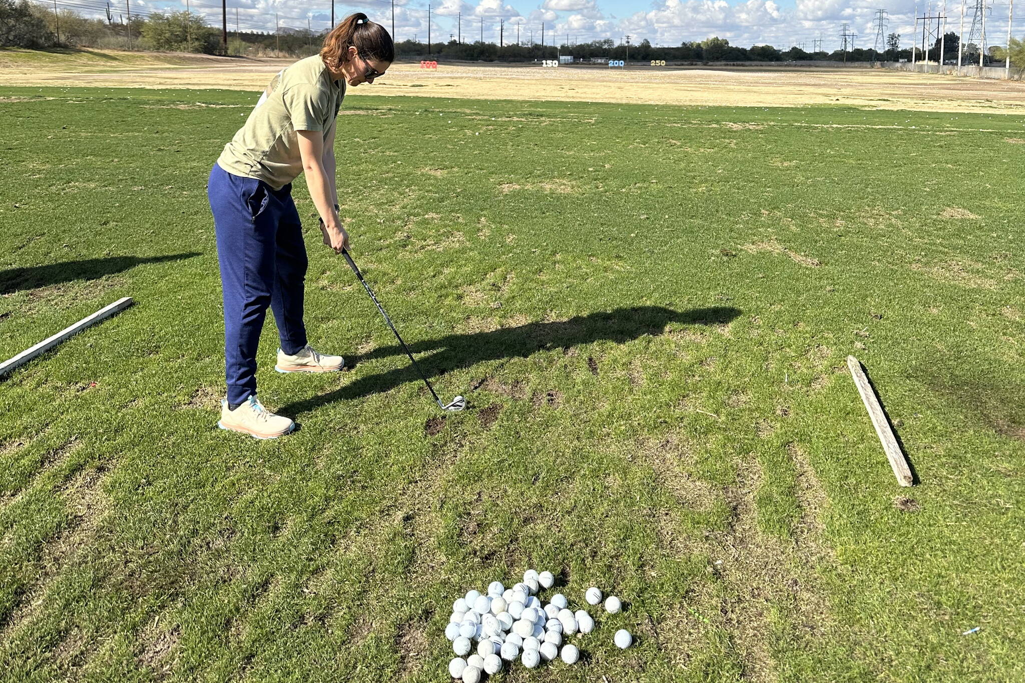 The author’s wife lines up to hit a golf ball at a driving range in Tucson last week. (Photo by Jeff Lund)