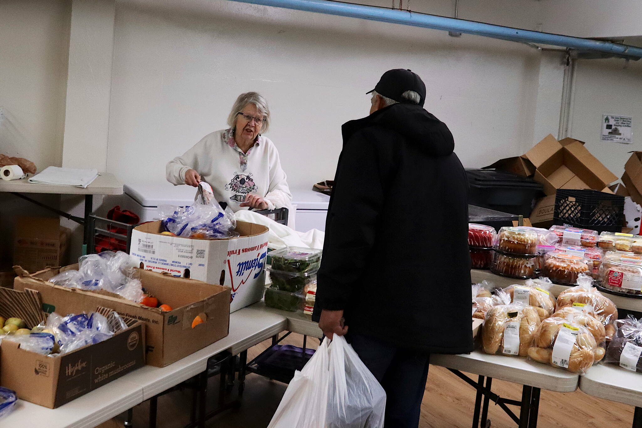 Sylvia Geraghty helps a customer during the weekly food pantry at Resurrection Lutheran Church on Tuesday, Dec. 6. (Mark Sabbatini / Juneau Empire file photo)