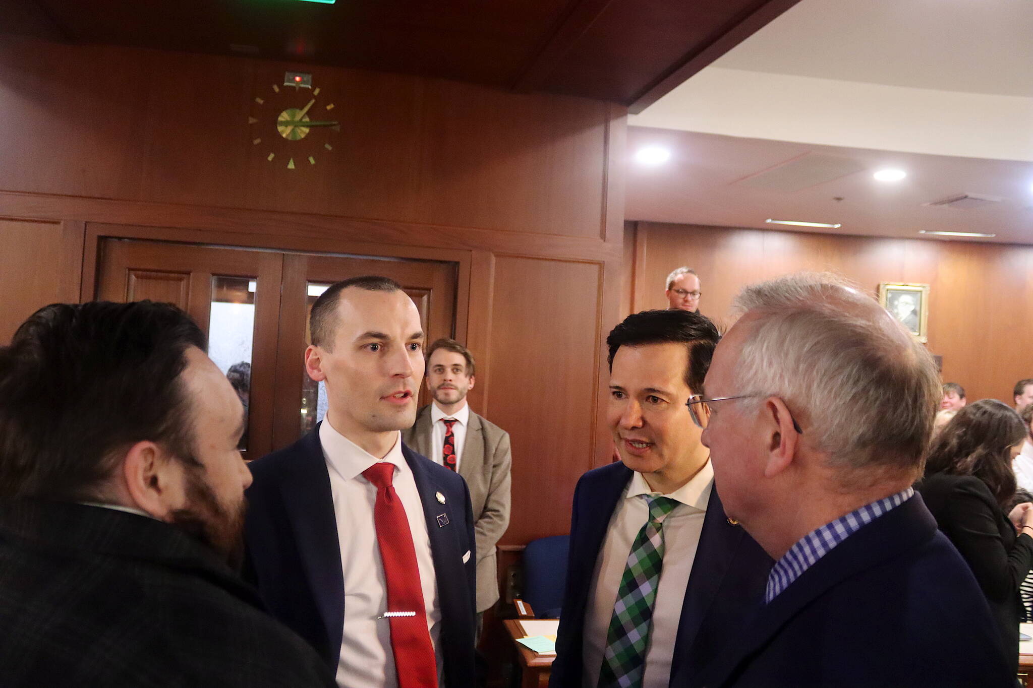 House Minority Leader Calvin Schrage (center), an Anchorage independent, talks with Reps. CJ McCormick, a Bethel Democrat, Neal Foster, a Nome Democrat, and Bryce Edgmon, a Dillingham independent, as a clock shows the midnight Thursday deadline for the 33rd Alaska Legislature to adjourn passed more than an hour earlier. (Mark Sabbatini / Juneau Empire)