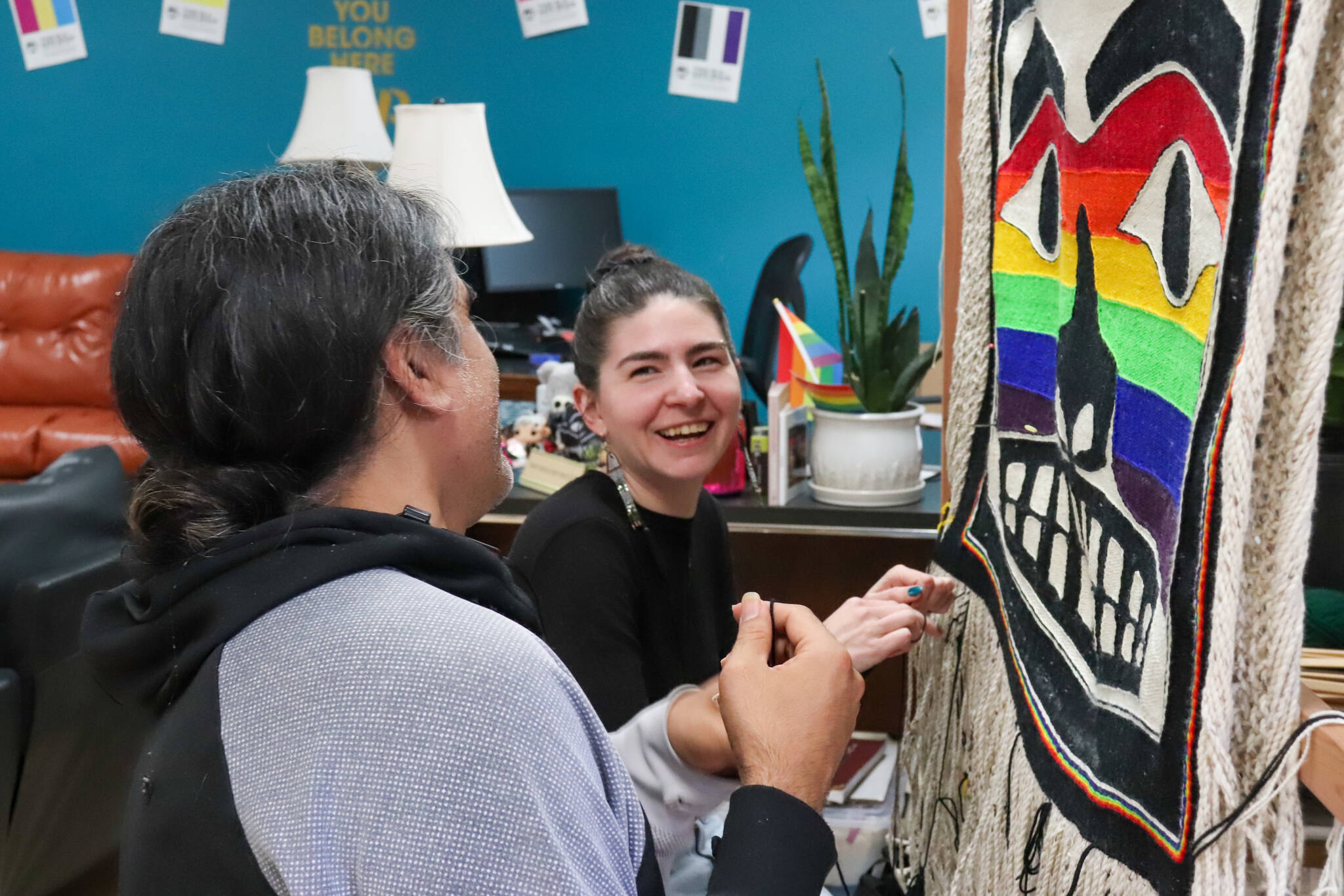 Melina Meyer and Laine Rinehart laugh while weaving the bottom fringe of the Chilkat Pride robe on Saturday. The robe will be exhibited and danced in for the first time during this year’s Celebration. (Jasz Garrett / Juneau Empire)