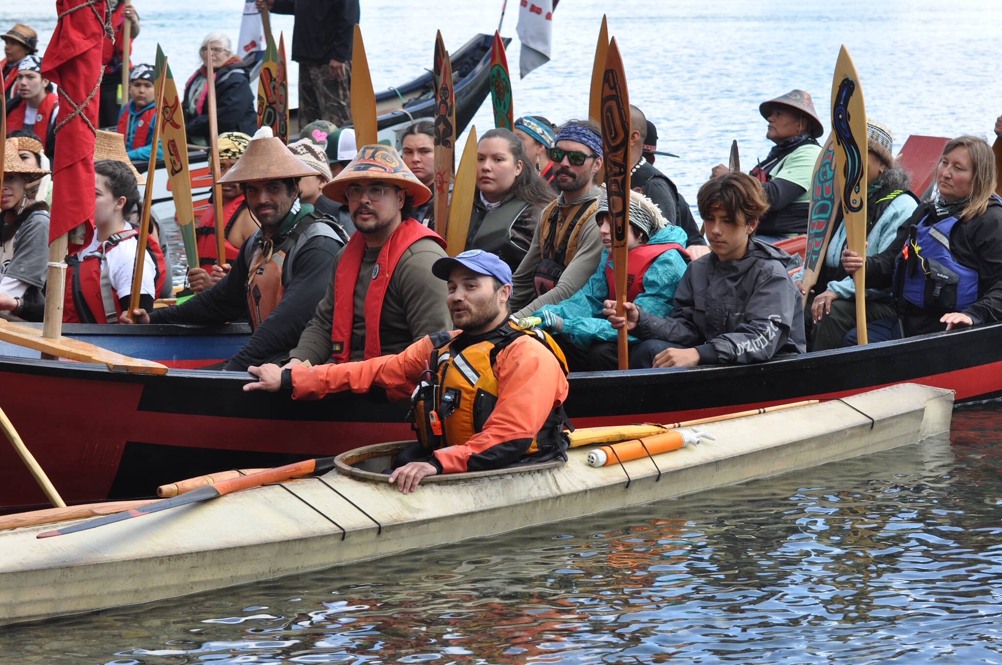 Paddlers in traditional Tlingit canoes, plus a smaller Bering Sea kayak guided by Lou Logan, arrive at the Auke Village Recreation Area at midday Tuesday following their journey down the northern part of the Inside Passage. (Laurie Craig / Juneau Empire)