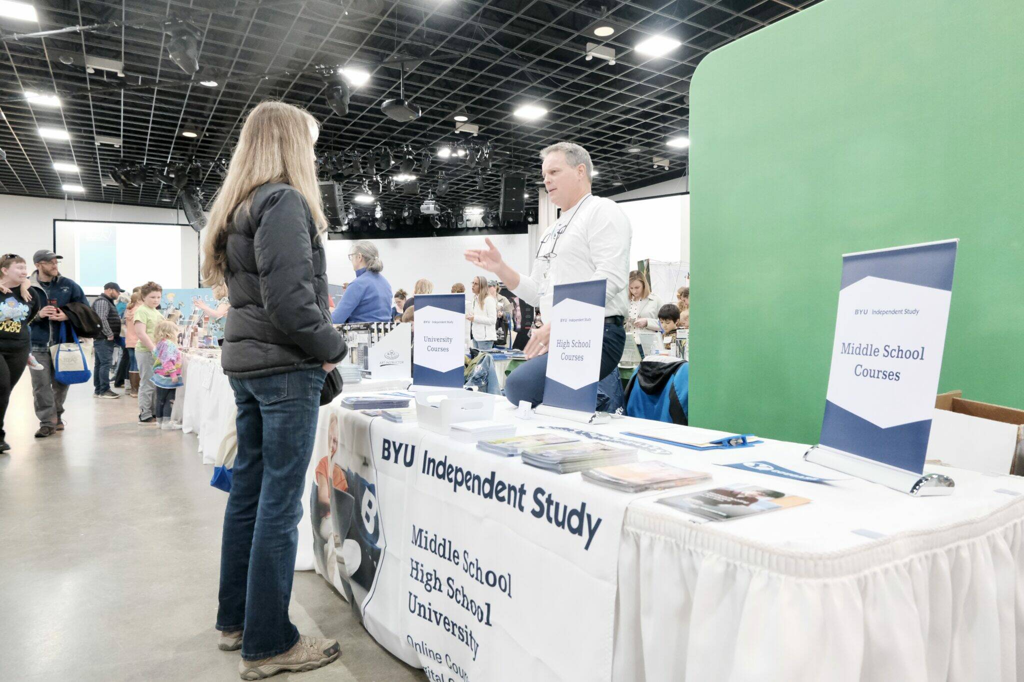 Dave Hoffman sells materials for Brigham Young University, a private religious college, at the IDEA Homeschool Curriculum Fair in Anchorage on April 18. (Claire Stremple/Alaska Beacon)