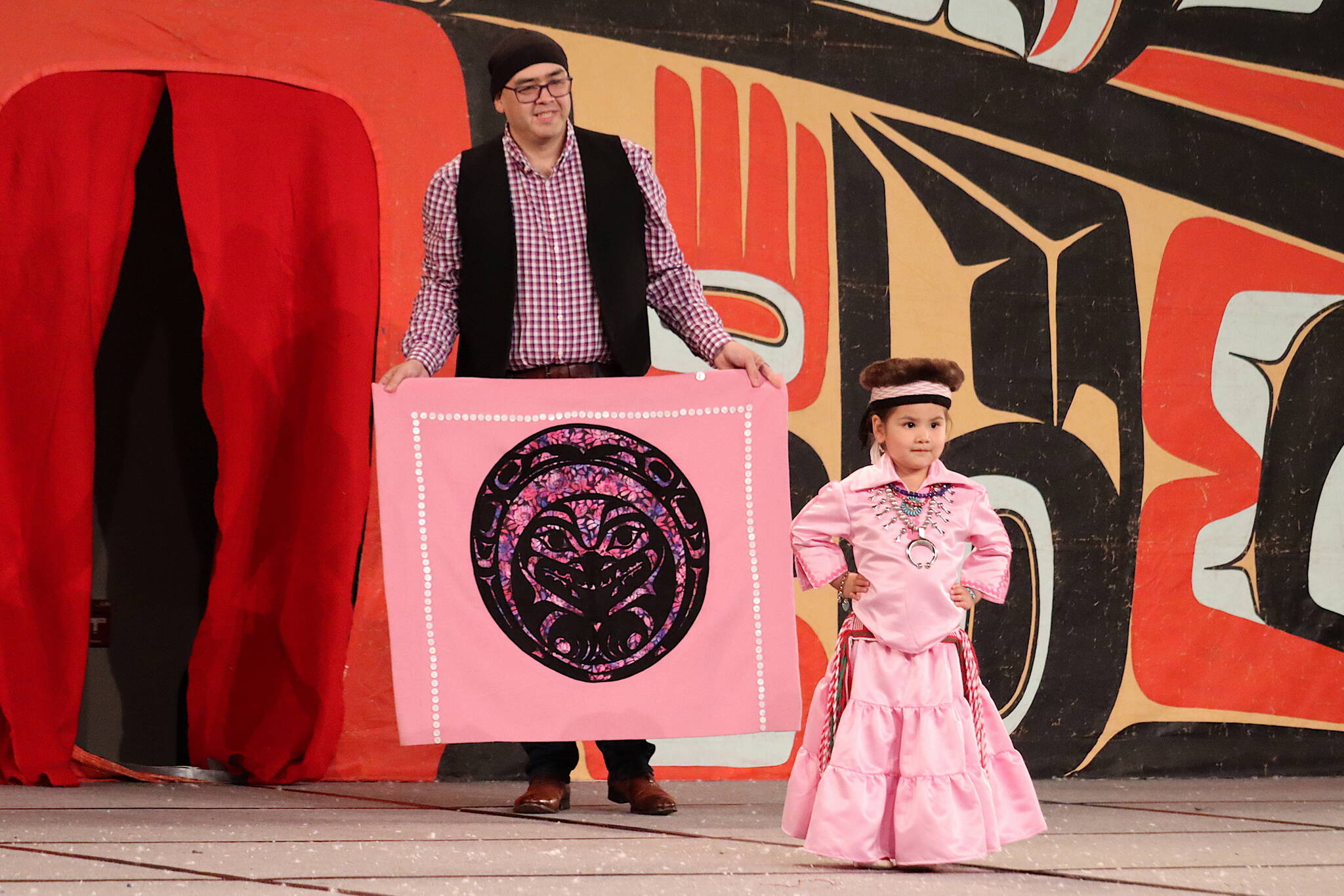Elizabeth Peele, 3, a Saxton resident, is accompanied by her father Charles during the toddler regalia review as part of Celebration on Thursday at Centennial Hall. (Mark Sabbatini / Juneau Empire)