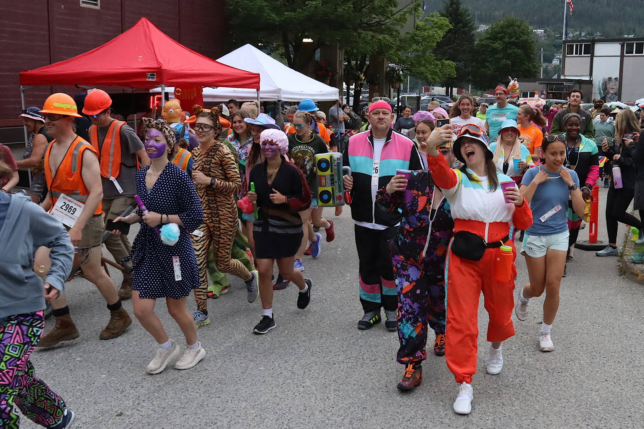 An estimated 185 people, many dressed in unconventional attire for running or walking, take off from the starting line outside Centennial Hall during the Only Fools Run At Night on Friday. (Mark Sabbatini / Juneau Empire)