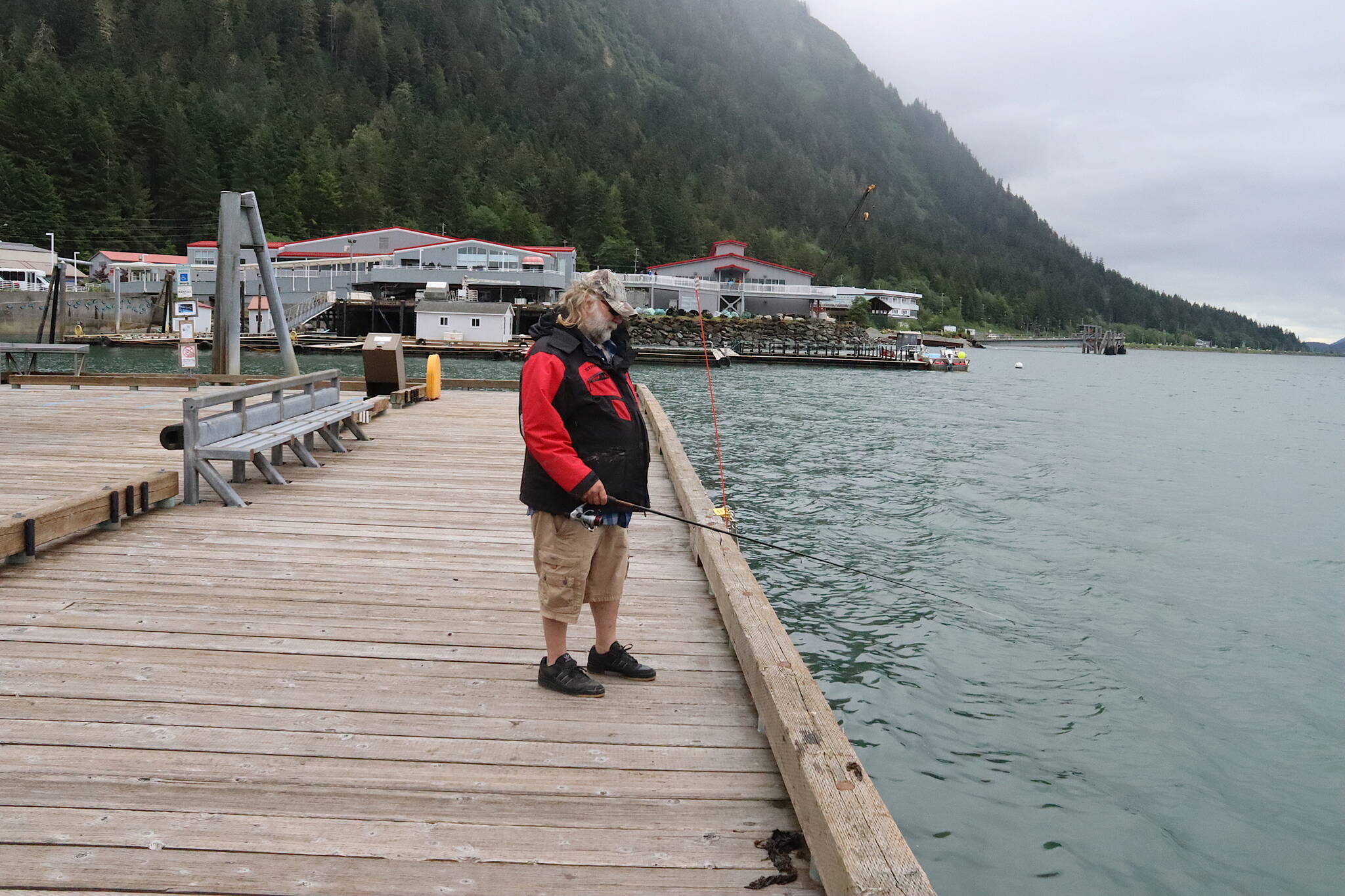 Tim Berry, a Michigan resident visiting Juneau, fishes on a dock Monday near the Douglas Island Pink and Chum Inc.’s Macaulay Salmon Hatchery. A ban catching king salmon near the hatchery and some other Juneau waters is in effect until Aug. 31. (Mark Sabbatini / Juneau Empire)