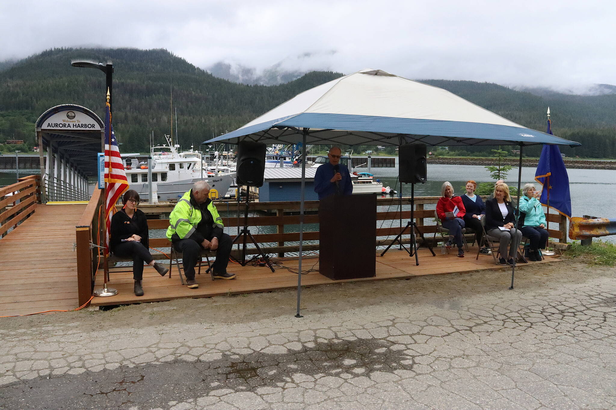 City and state leaders gather Monday at the gangway to Aurora Harbor for a ribbon-cutting ceremony to celebrate the completion of the third of four stages of reconstruction of the 60-year-old harbor. (Mark Sabbatini / Juneau Empire)