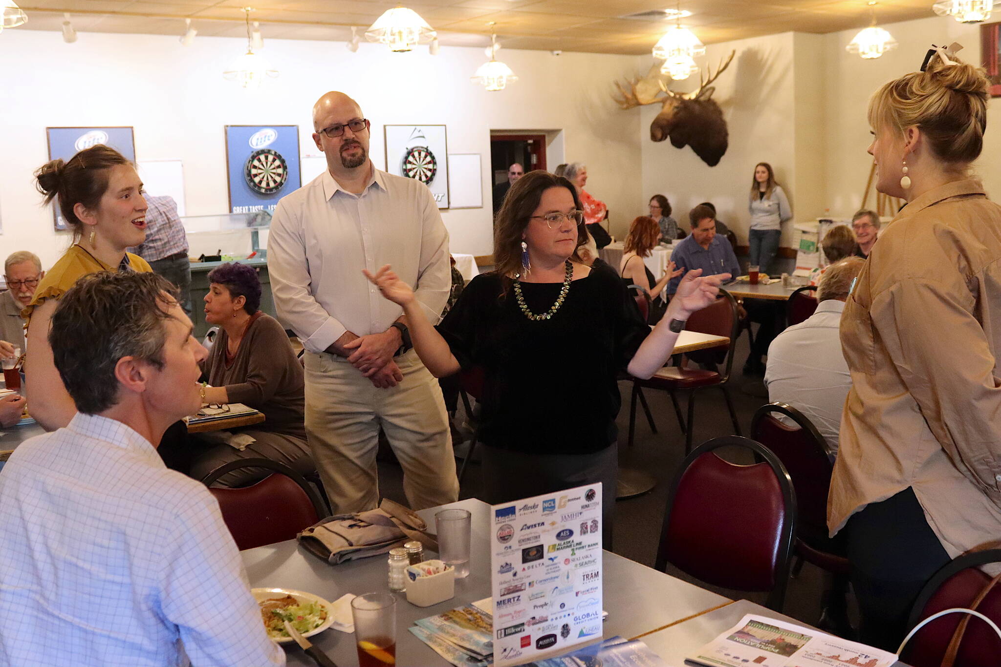 Meilani Schijvens (center), owner of Rain Coast Data, talks with attendees at a Juneau Chamber of Commerce luncheon on Thursday before presenting results from an annual economic survey by her company. (Mark Sabbatini / Juneau Empire)