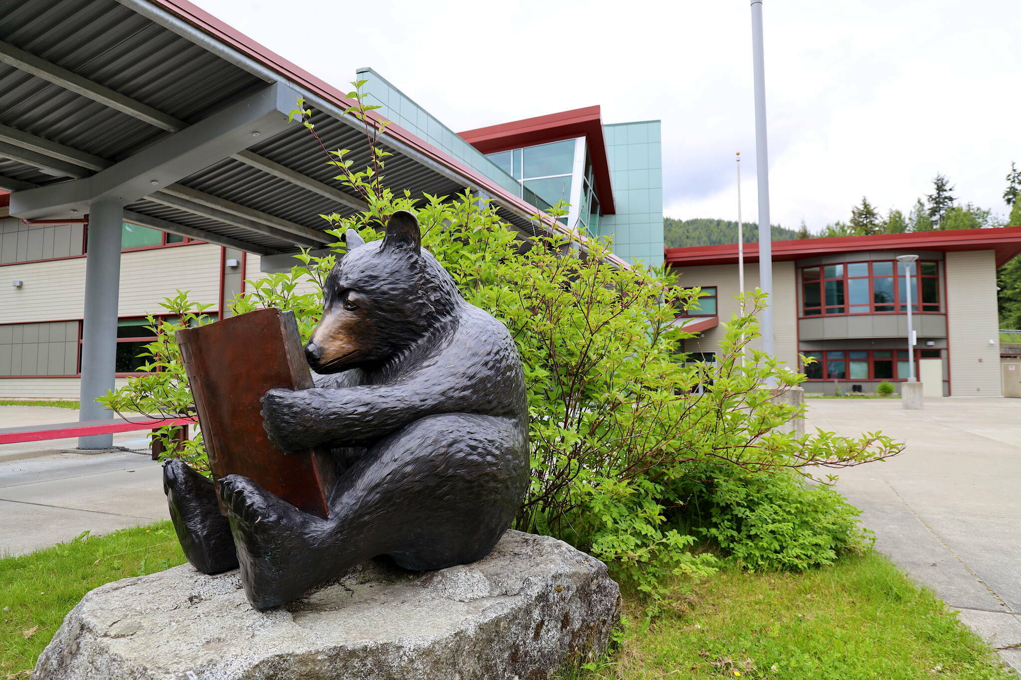 A sculpture of a bear reading a book is seen in front of Auke Bay Elementary School on July 12, 2023. (Clarise Larson / Juneau Empire file photo)