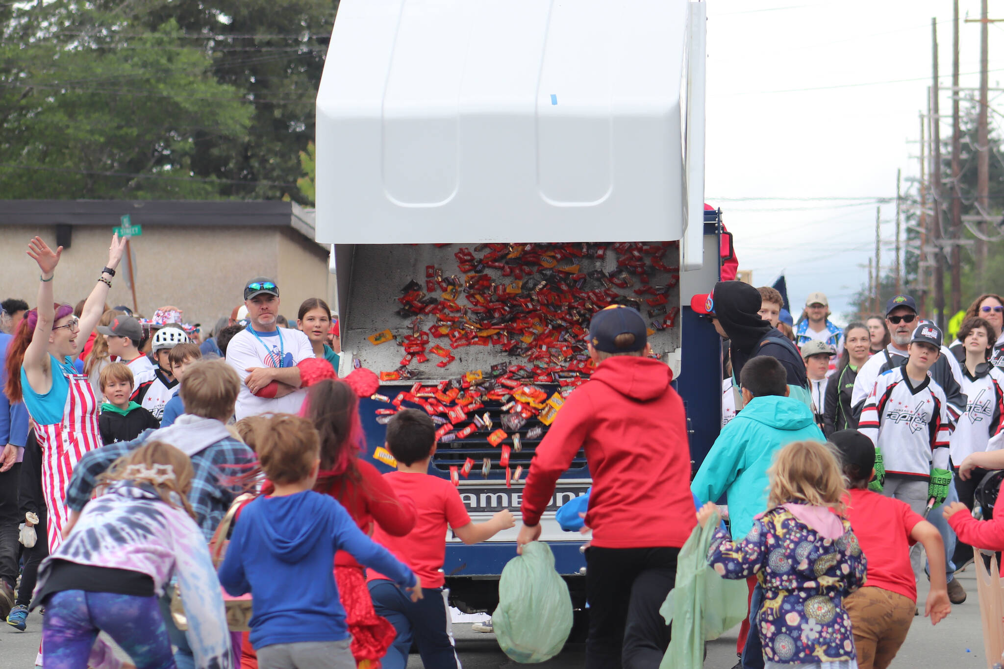 Children run as fast as they can toward Treadwell Arena’s zamboni as it fills the street with candy during the Fourth of July parade on Douglas. (Jasz Garrett / Juneau Empire)