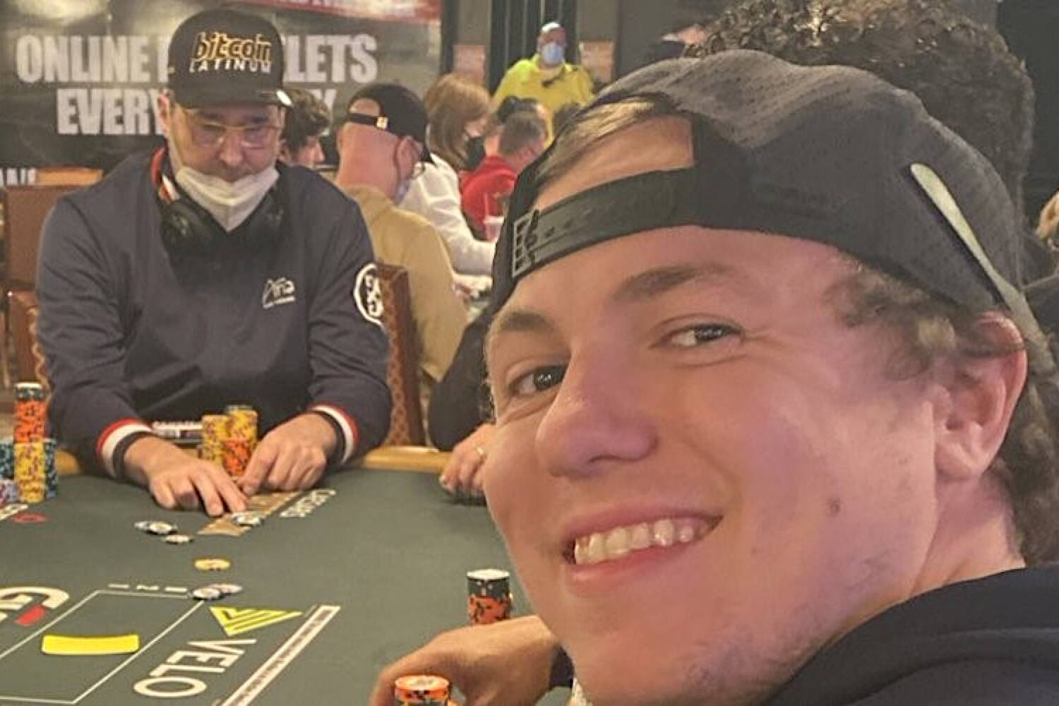 Juneau’s Jacob Thibodeau (right) takes a selfie with WSOP legend Phil Hellmuth in the background. (Photo provided by Alaska Sports Report)