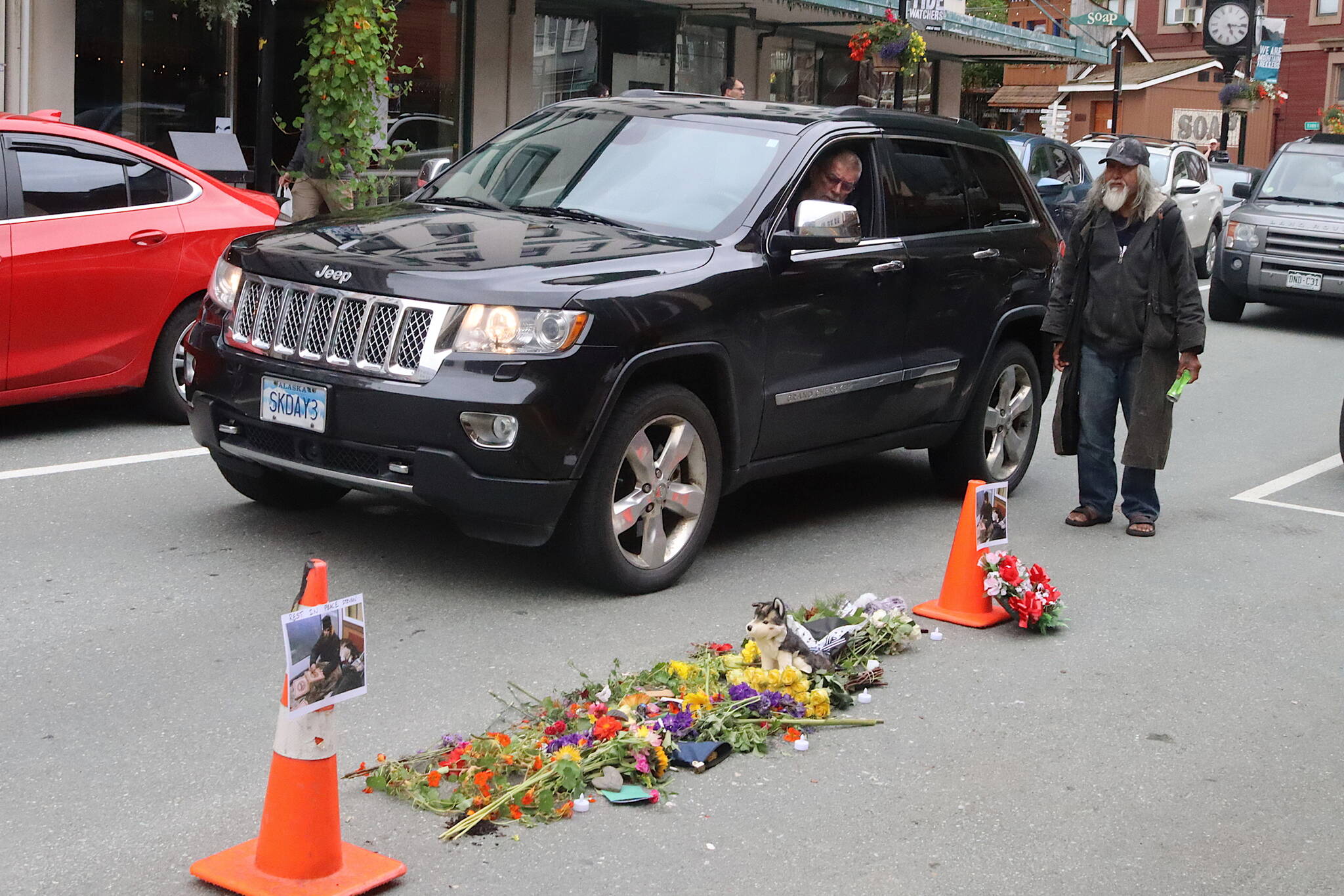 People pass by a memorial Tuesday evening for Steven Kissack at the site he was fatally shot by police on Monday. (Mark Sabbatini / Juneau Empire)