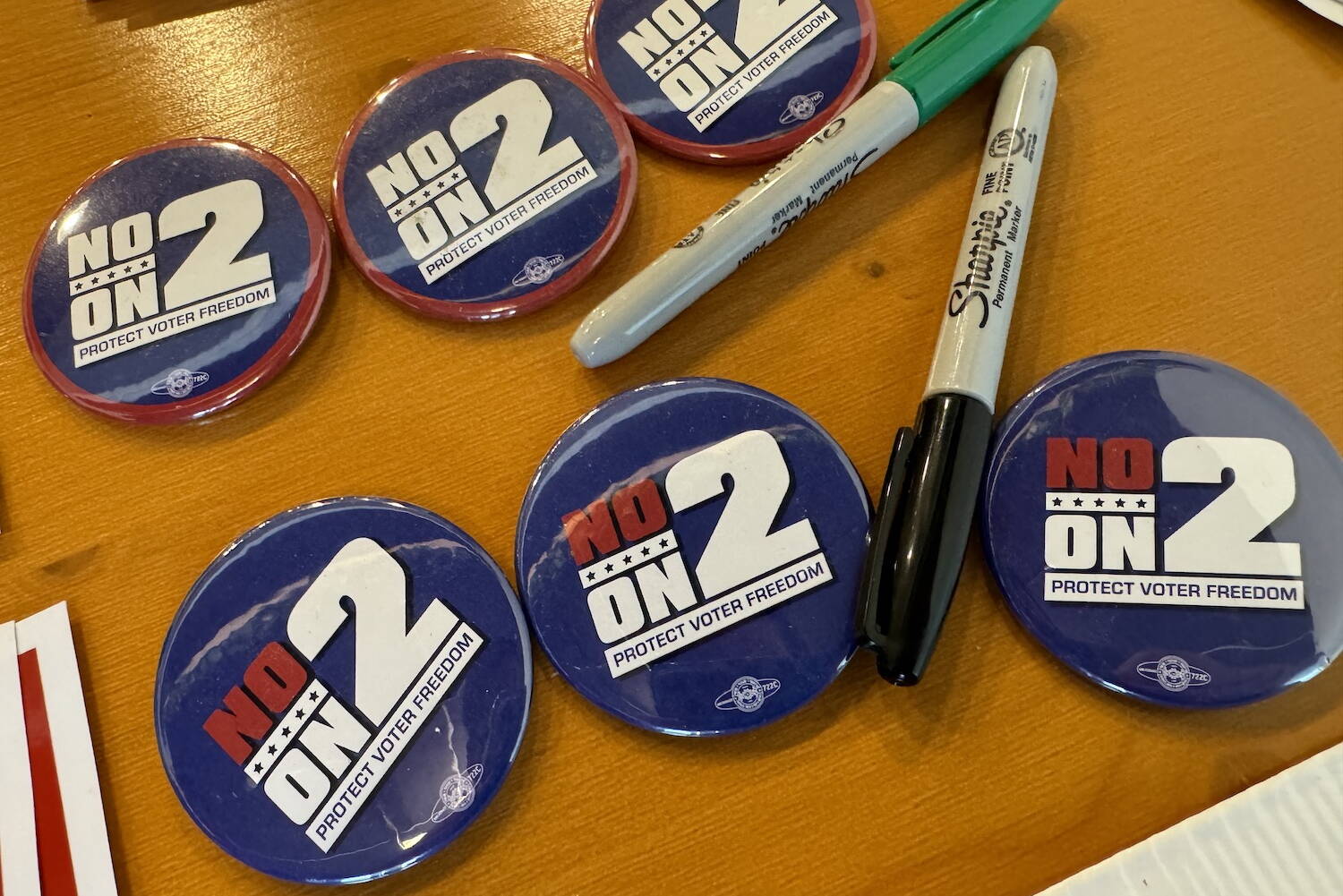 Buttons on display at a campaign event Monday, July 8, 2024, in Juneau, urge supporters to vote against Ballot Measure 2, the repeal of Alaska’s current election system. (James Brooks/Alaska Beacon)