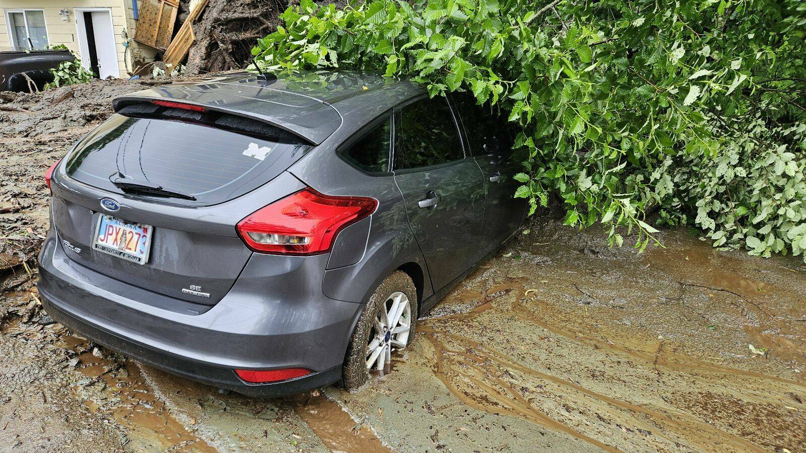 A car on Gastineau Avenue is partially buried by a mudslide that occurred during record rainfall on Sunday, July 14, 2024. (Photo by Simba Blackman)