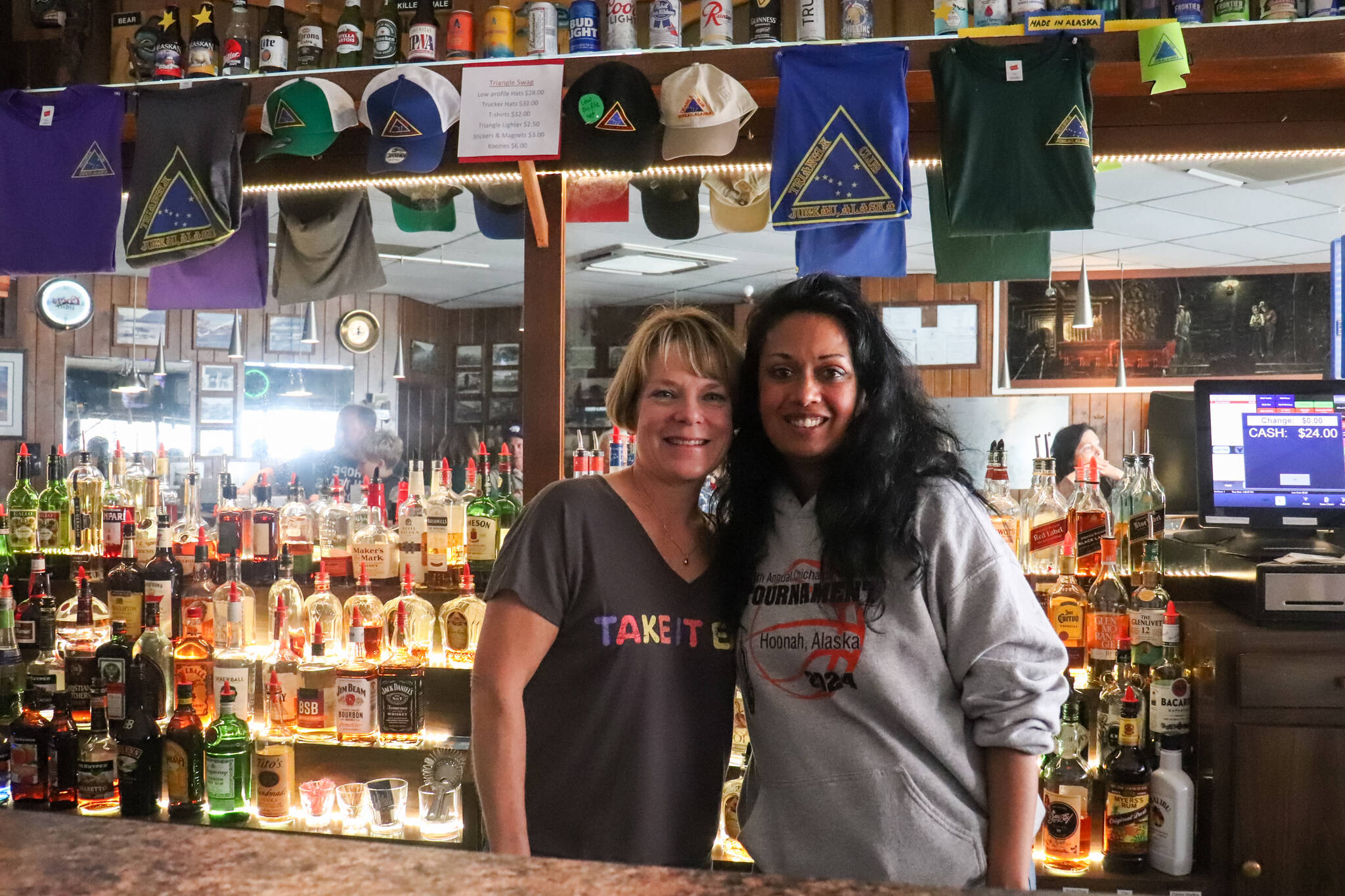 Leeann Thomas, the owner of the Triangle Club for the last 25 years, stands behind the bar with her employee Dita Sharpley on Tuesday. (Jasz Garrett / Juneau Empire)