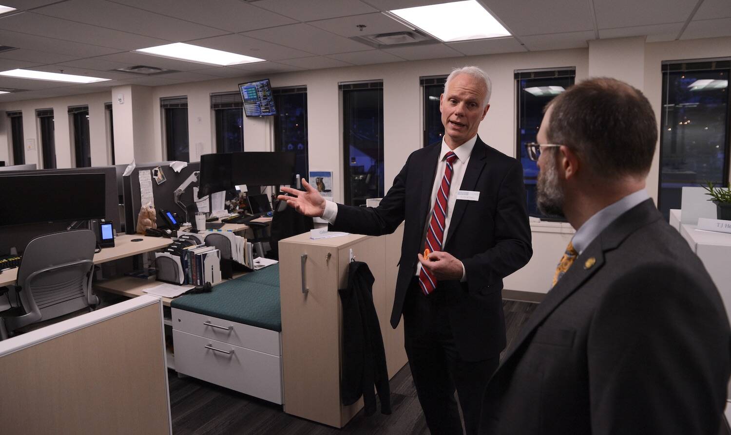 Deven Mitchell, executive director of the Alaska Permanent Fund Corp., gives a tour of the corporation’s investment floor to Sen. Jesse Kiehl, D-Juneau, and other attendees of an open house on Friday, Feb. 16, 2024. (James Brooks/Alaska Beacon)