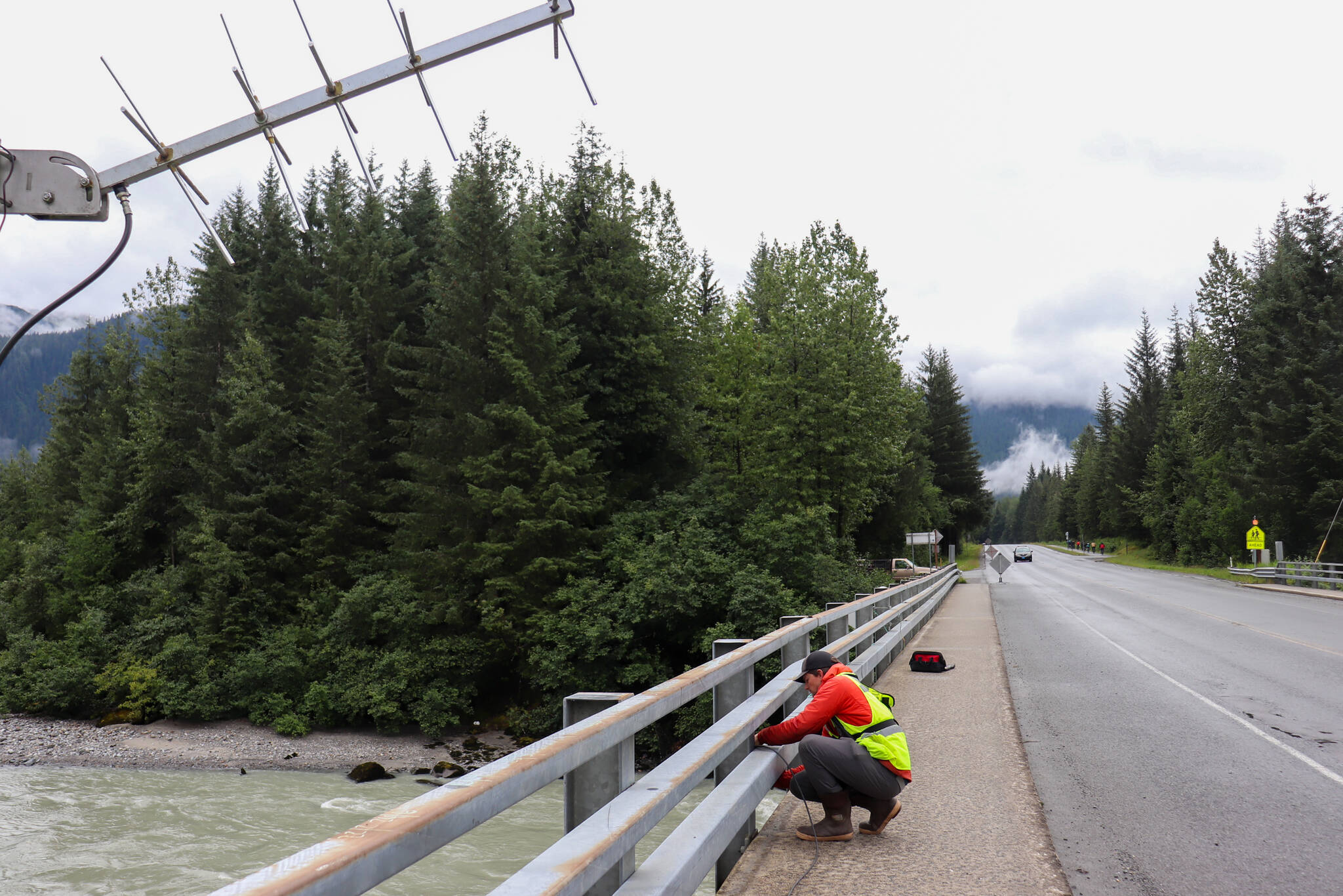 Jonathan Tuttle, a hydrologist with the U.S. Geological Survey, installs monitoring equipment at the Mendenhall River bridge on Back Loop Road Thursday morning. (Jasz Garrett / Juneau Empire)