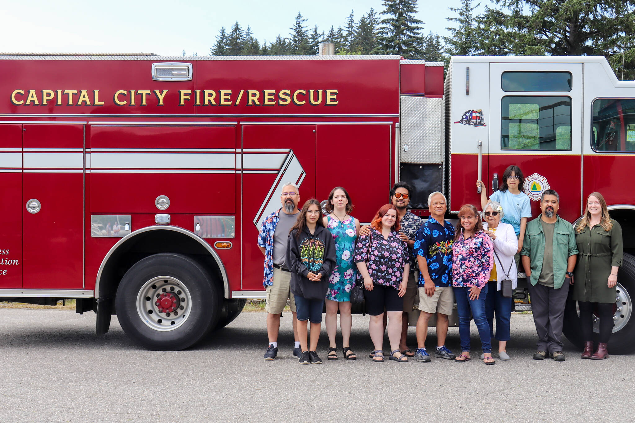 Retired Capital City Fire/Rescue Assistant Chief Ed Quinto takes a photo with his family at the Hagevig Regional Fire Training Center on Saturday. (Jasz Garrett / Juneau Empire)