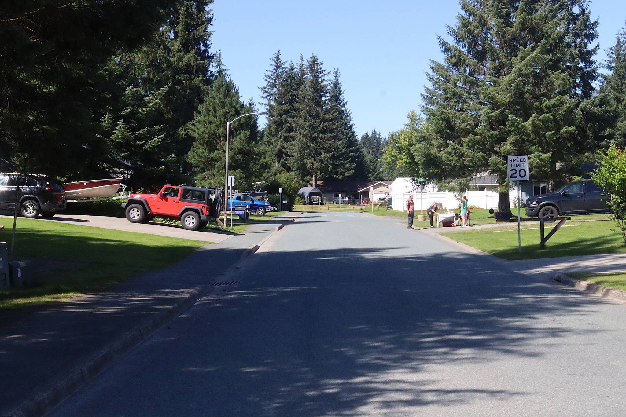 Residents on Meander Way gather around a stand selling drinks, cookies and handmade trinkets early Sunday afternoon, a few hours after a flood warning was issued for the neighborhood due to a glacier outburst flood from Suicide Basin. Residents along the street, whose homes and yards were infiltrated by water from record flooding last year, said they are making contingency plans as they keep an eye on the water, but not fleeing their homes yet. (Mark Sabbatini / Juneau Empire)