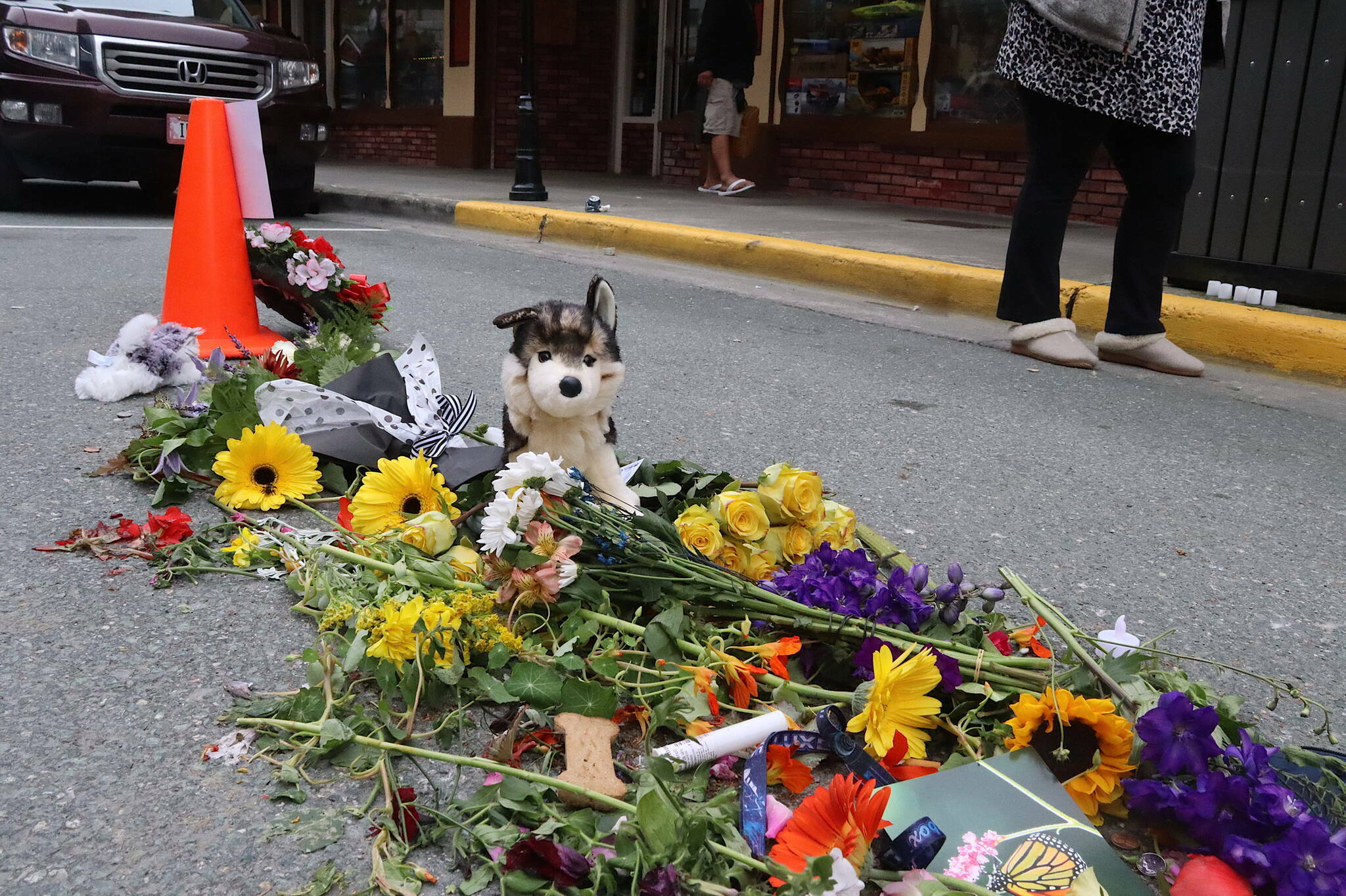 Flowers, notes, cash donations and other items are placed Tuesday, July 16, 2024, at a memorial for Steven Kissack, a longtime Juneau resident experiencing homelessness, at the spot he was fatally shot by police the previous day. The stuffed malamute is in recognition of his dog Juno, who was present when the shooting occurred. (Mark Sabbatini / Juneau Empire file photo)