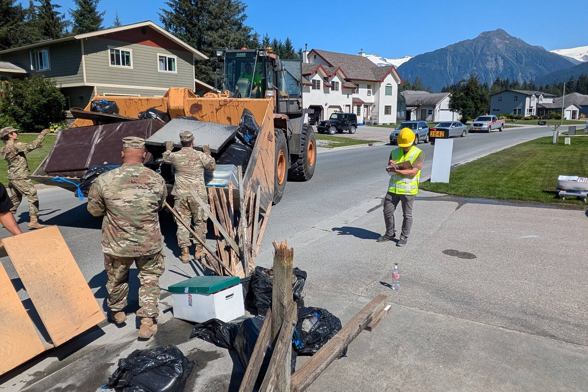 Alaska National Guard members help clear debris Thursday from a neighborhood hit by record flooding of the Mendenhall River earlier this week. (Alaska National Guard photo)