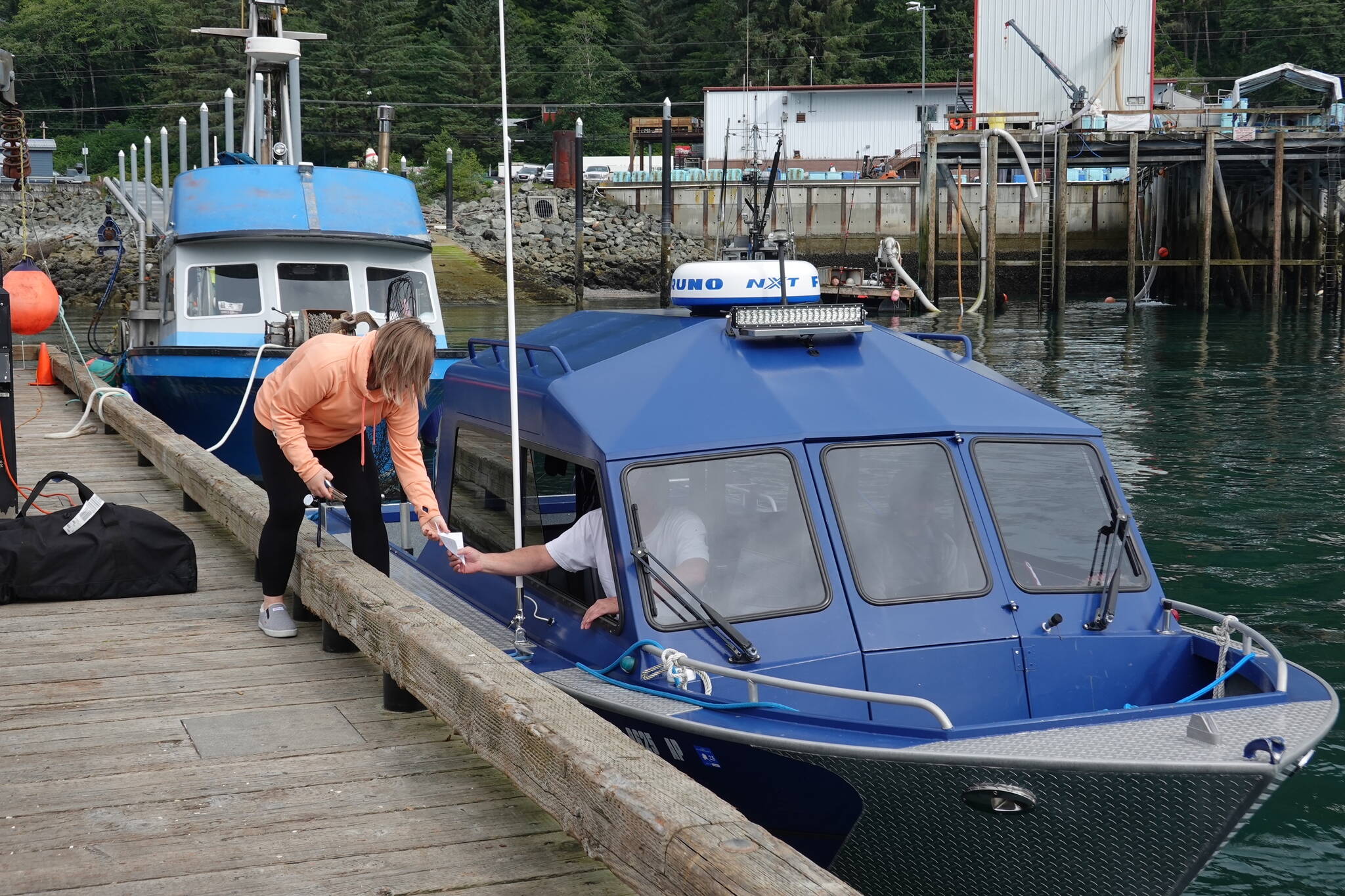 Alysha Reeves, a nine-year Golden North Salmon Derby official, validates a fisherman’s ticket at the Auke Nu weigh station on Friday morning, the first day of the three-day derby. (Laurie Craig / Juneau Empire)