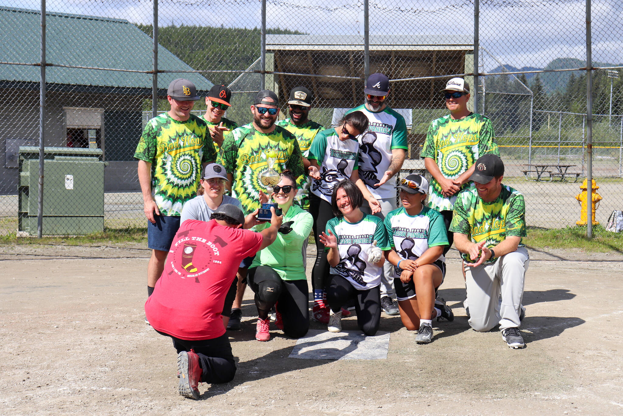 Firefighter Sylvester Olivares-Ramos bows down to give the U.S. Coast Guard softball team their first-place trophy in the Alaska Peace Officer Association’s charity softball tournament on Saturday that fundraises for Special Olympics Alaska. (Jasz Garrett / Juneau Empire)