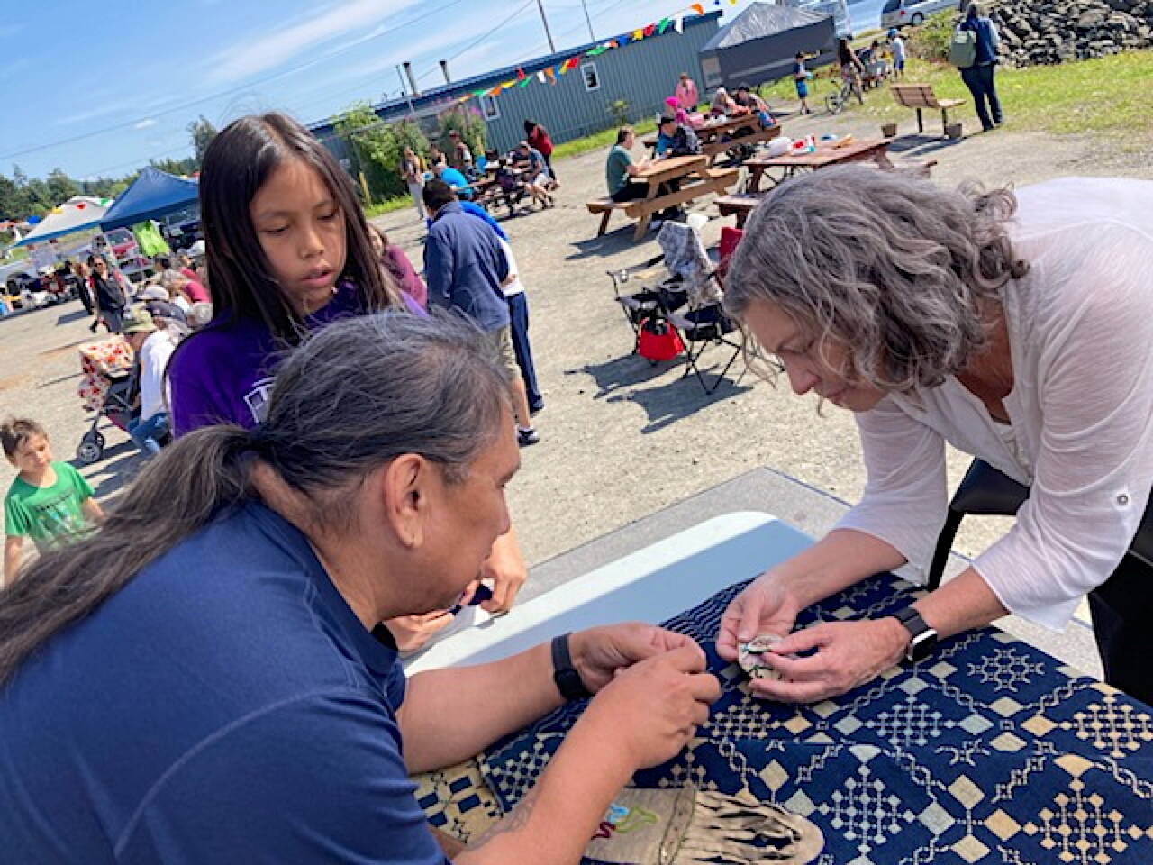 At the Kake Dog Salmon Festival on Saturday, Aug. 3, 2024, residents and visiting Quakers examined artifacts returned to the village by the ancestor of a Quaker missionary. (Photo courtesy of Jan Bronson)