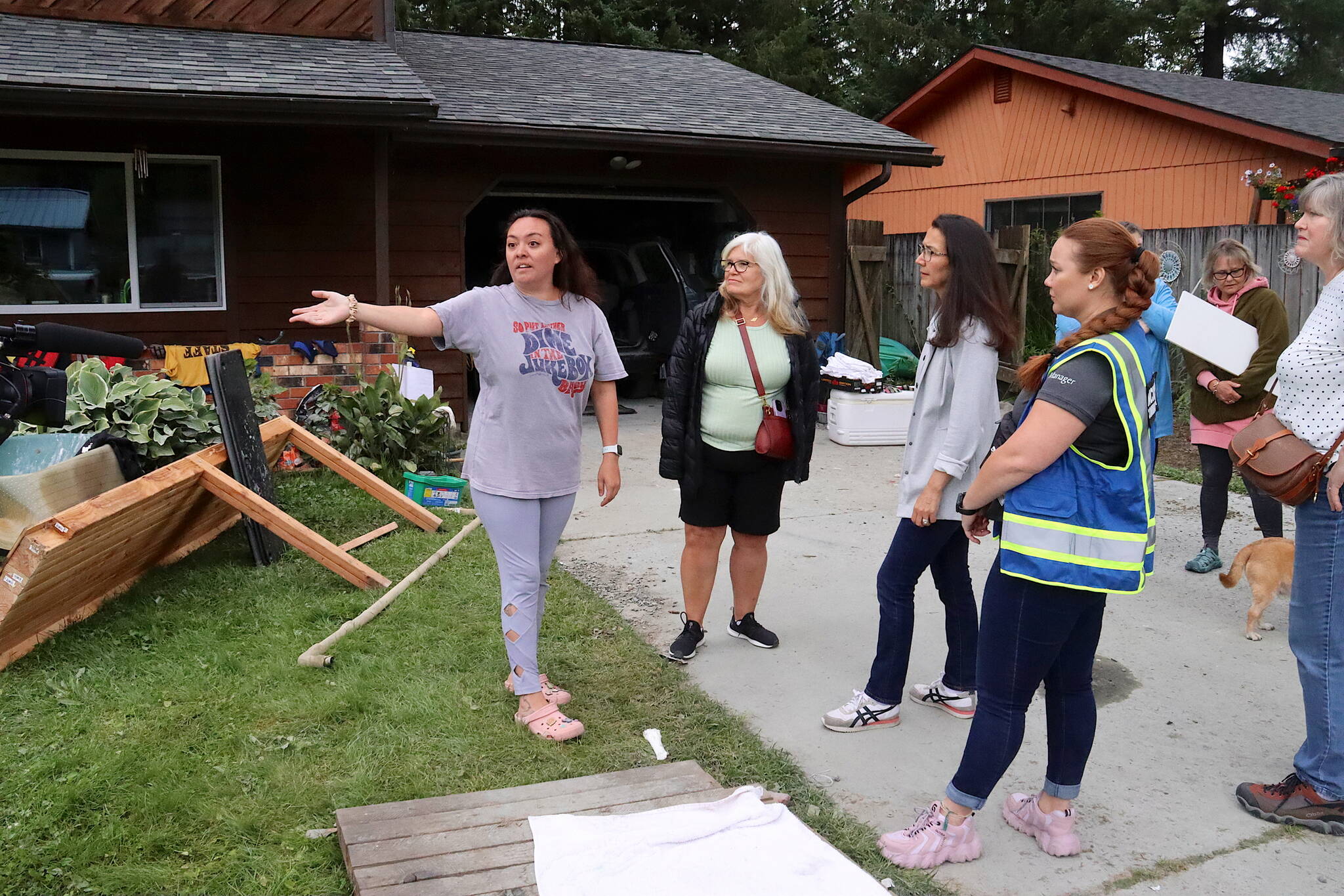 Tesla Cox (left) explains the damage done to her home and possessions by a record flood to a delegation of leaders on Sunday including (from left in foreground) Tlingit and Haida Regional Housing Authority President Jacqueline Pata, U.S. Rep. Mary Peltola, Tlingit and Haida Tribal Emergency Operations Center Incident Commander Sabrina Grubitz, and Juneau state Rep. Sara Hannan. (Mark Sabbatini / Juneau Empire)