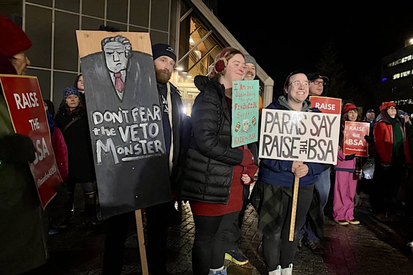 People carry signs at a Juneau rally in favor of an increase to the amount the government pays schools per student on Jan. 29, 2024. (Claire Stremple/Alaska Beacon)