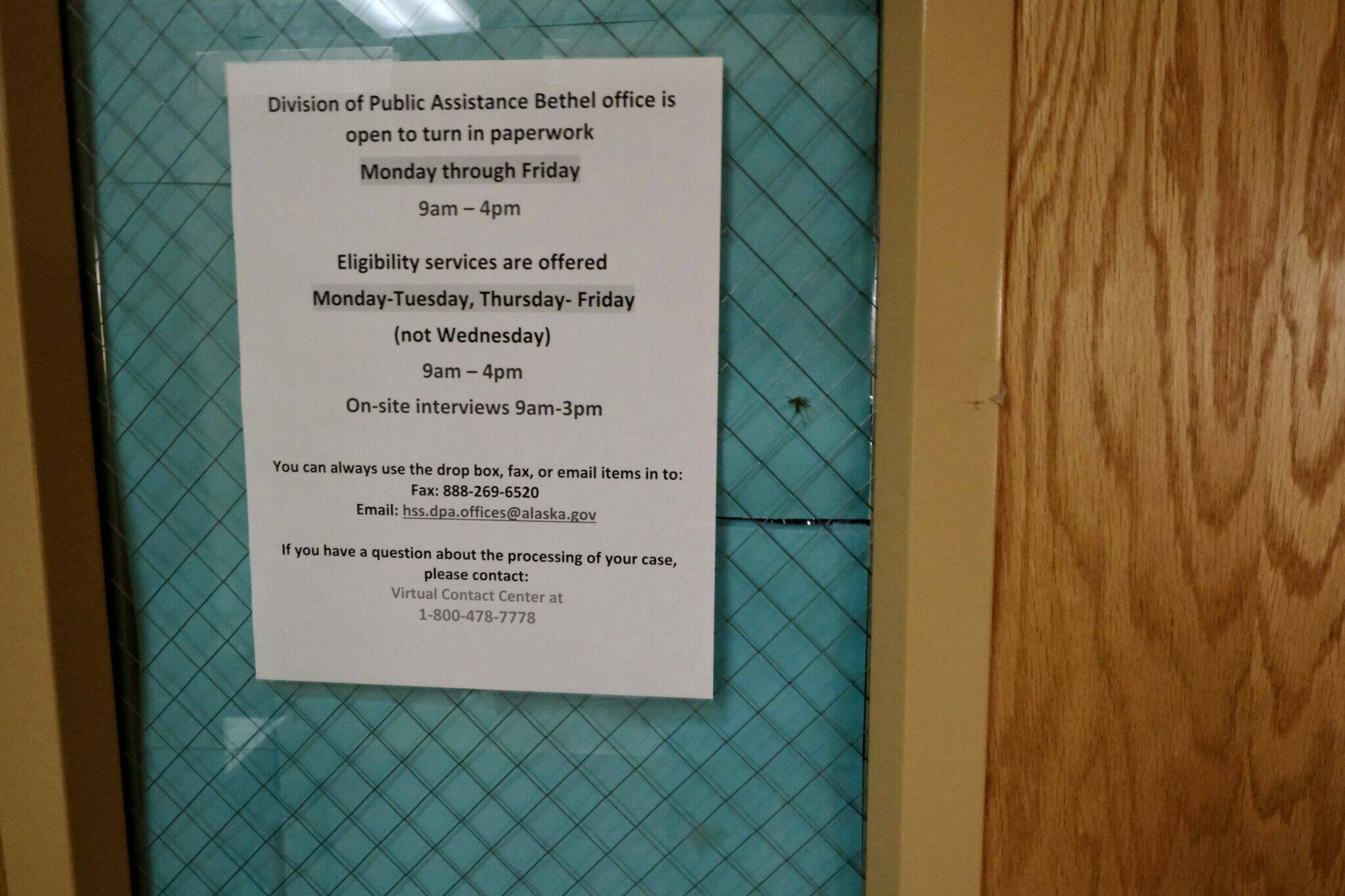 A sign posted on the door of the Division of Public Assistance office in Bethel, Alaska, on Oct. 11, 2023. The office offers full services. (Claire Stremple/Alaska Beacon)