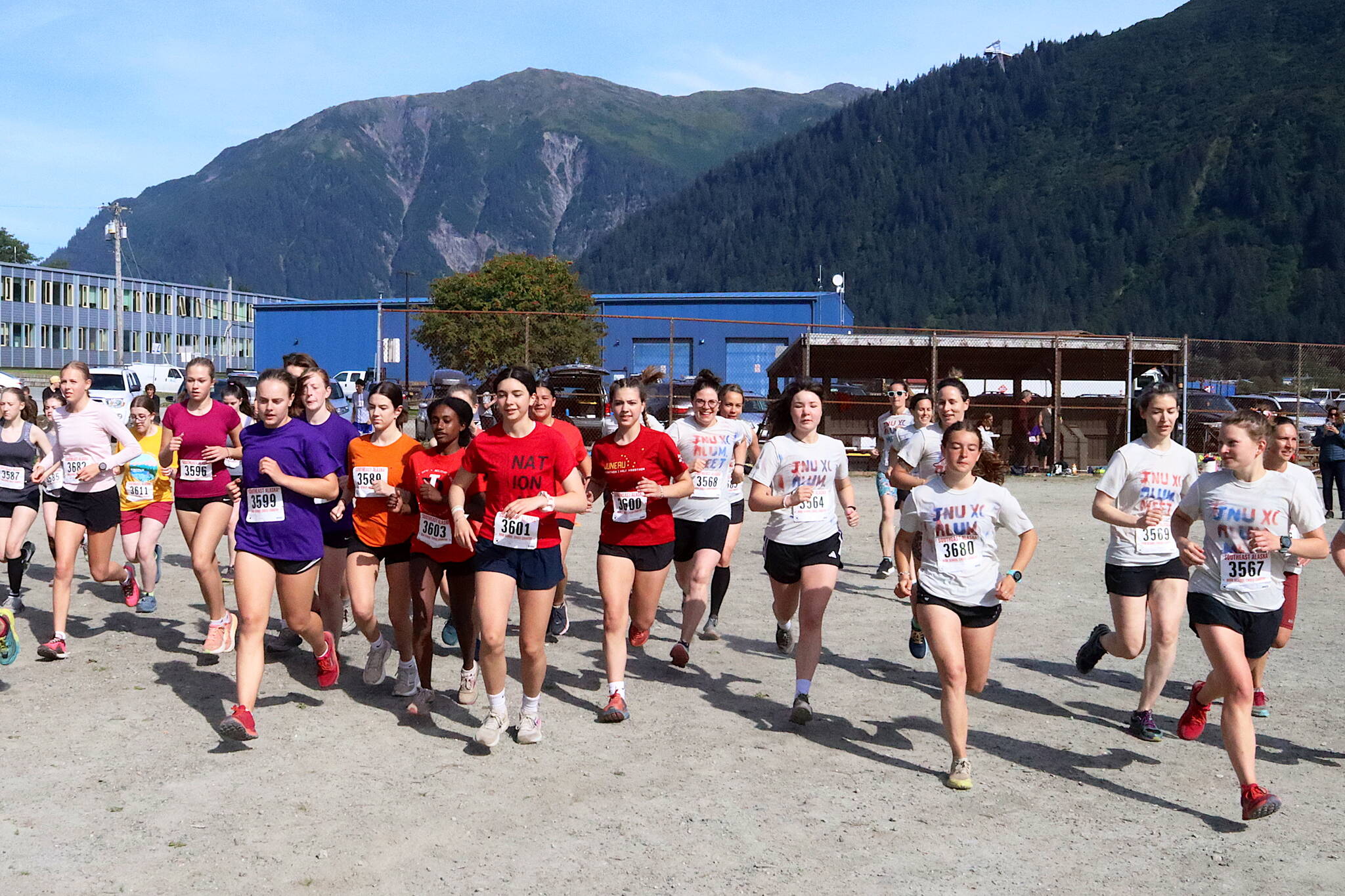 Juneau high school students and alumni take off from the starting line in the women’s 5K race of the Sayéik Invitational at Savikko Park on Saturday morning. The unofficial meet was the first event of the season for the cross-country team newly consolidated Juneau-Douglas High School: Yadaa.at Kalé. (Mark Sabbatini / Juneau Empire)