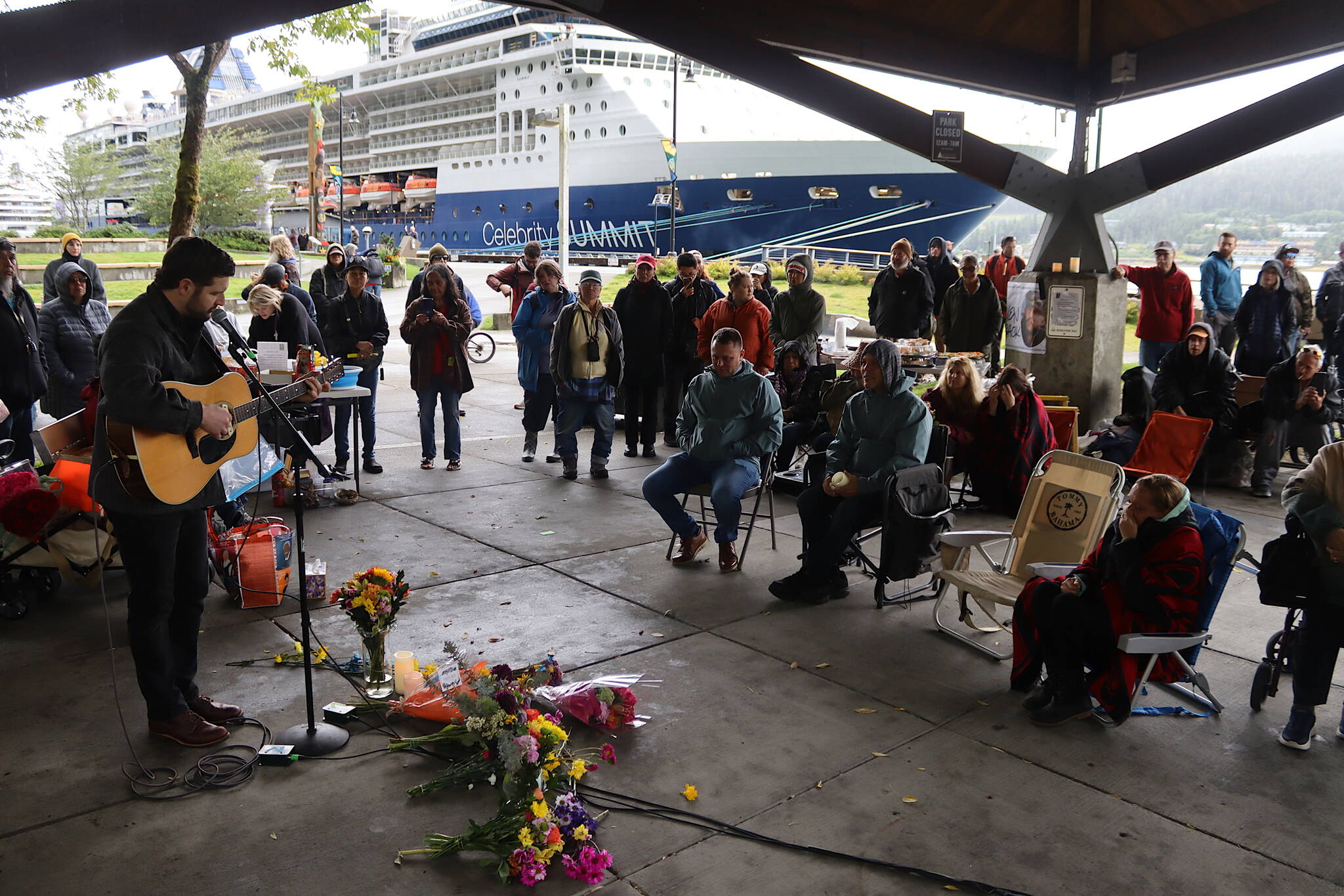 Josh Fortenbery performs a song written about Steven Kissack as three of his siblings, seated, listen during a memorial gathering Sunday at Marine Park. (Mark Sabbatini / Juneau Empire)