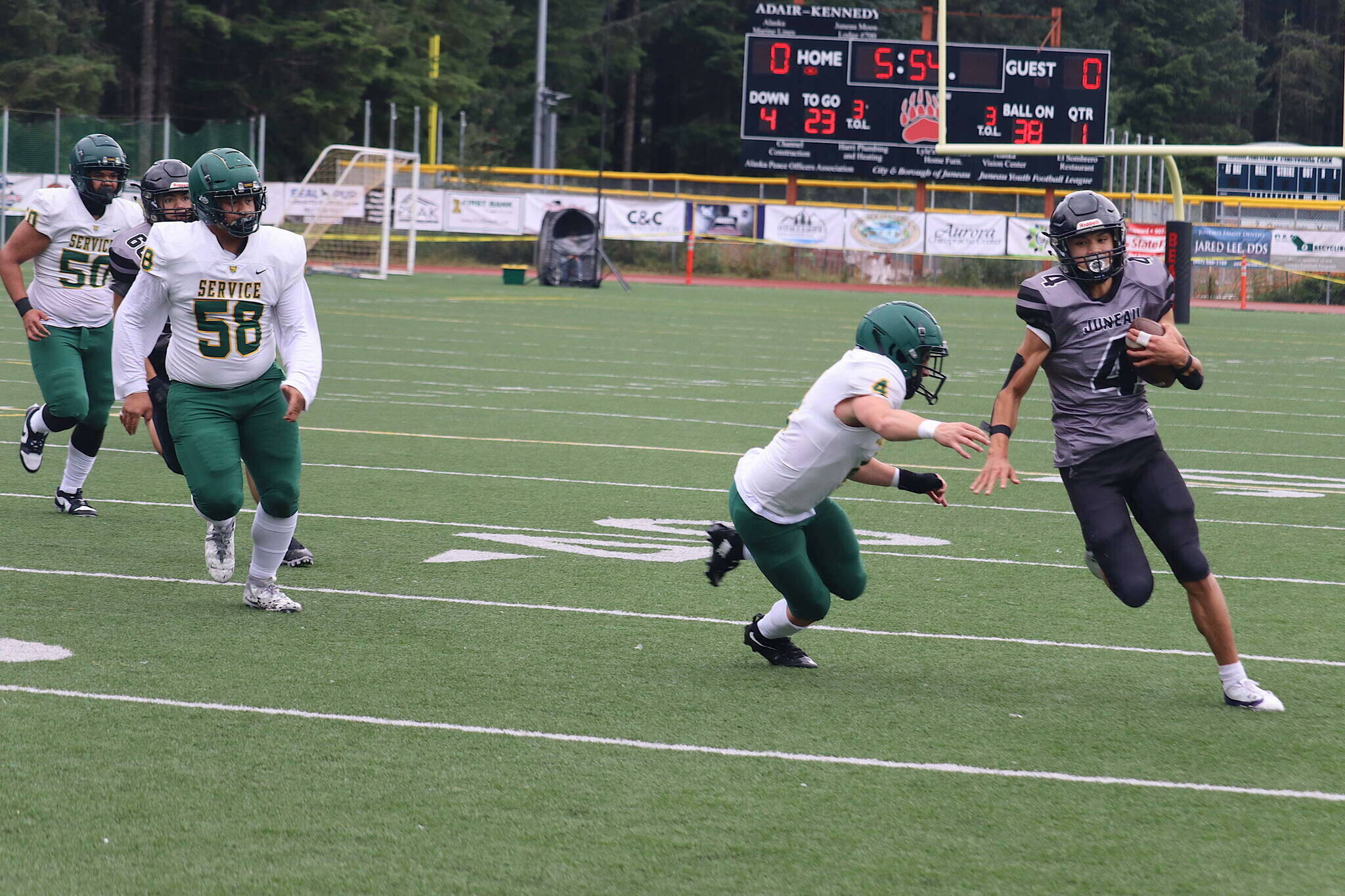 Jayden Johnson (4) eludes a Service High School tackler while running a fake punt in for a touchdown during the first quarter of Juneau-Douglas High School: Yadaa.at Kalé’s first home game of the season Saturday at Adair-Kennedy Memorial Park. (Mark Sabbatini / Juneau Empire)