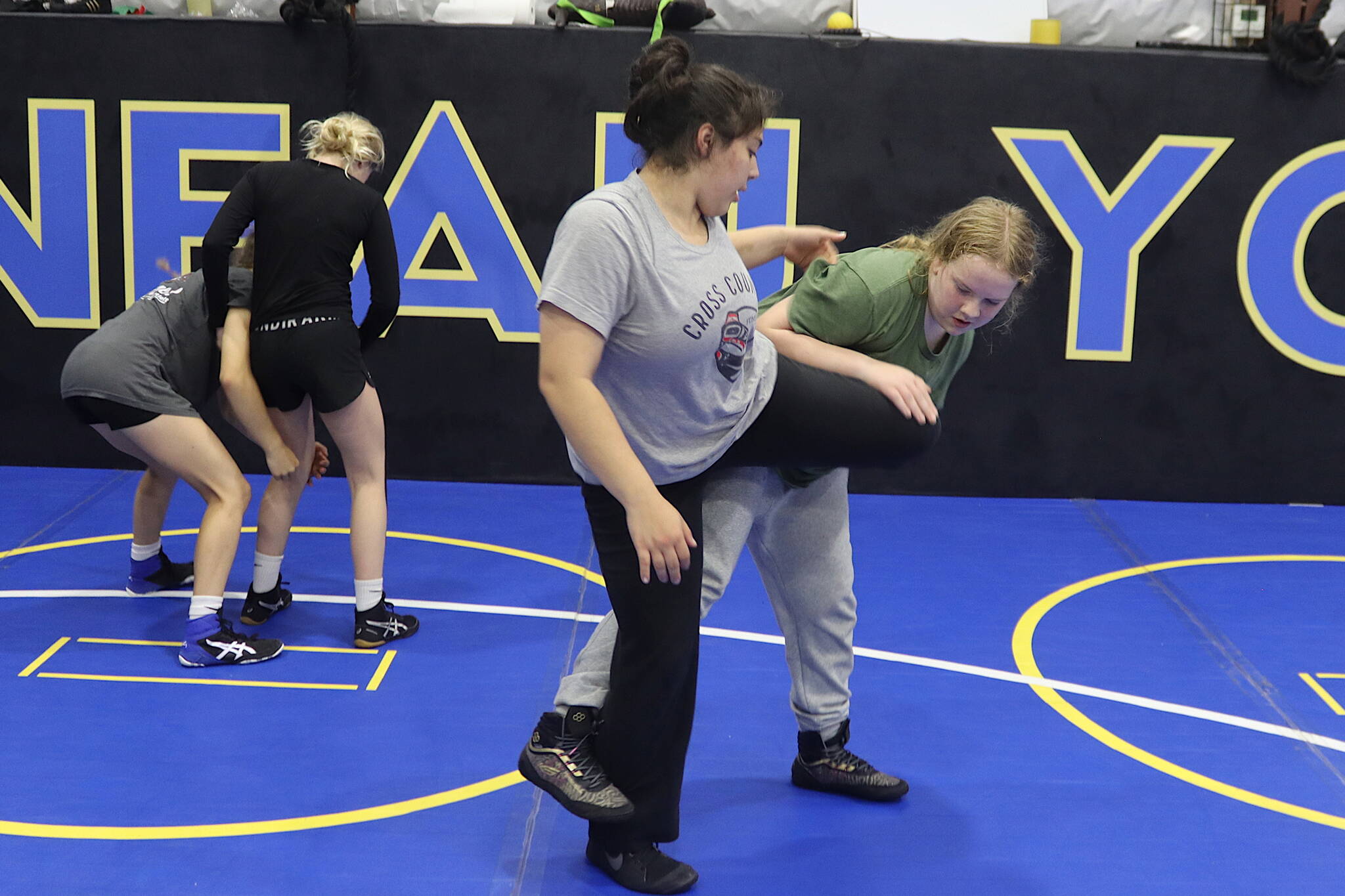 Abby Dolan (wearing green) tries to take down Sofia Contreras during a Juneau Youth Wrestling Club camp Sept. 1 at the Juneau Wrestling Center. (Mark Sabbatini / Juneau Empire)