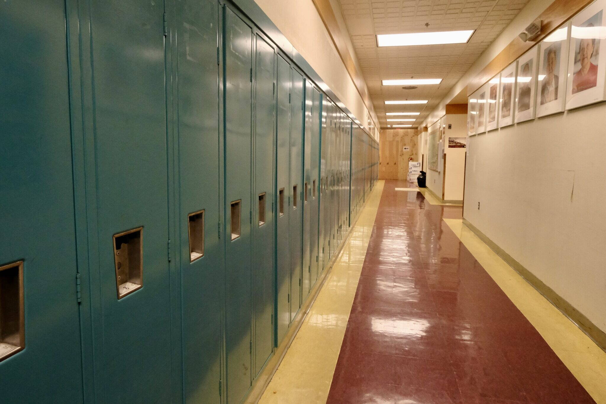 The halls are lined with lockers and portraits of elders at the Anna Tobeluk Memorial School in Nunapitchuk on Oct. 12, 2023. (Claire Stremple/Alaska Beacon)