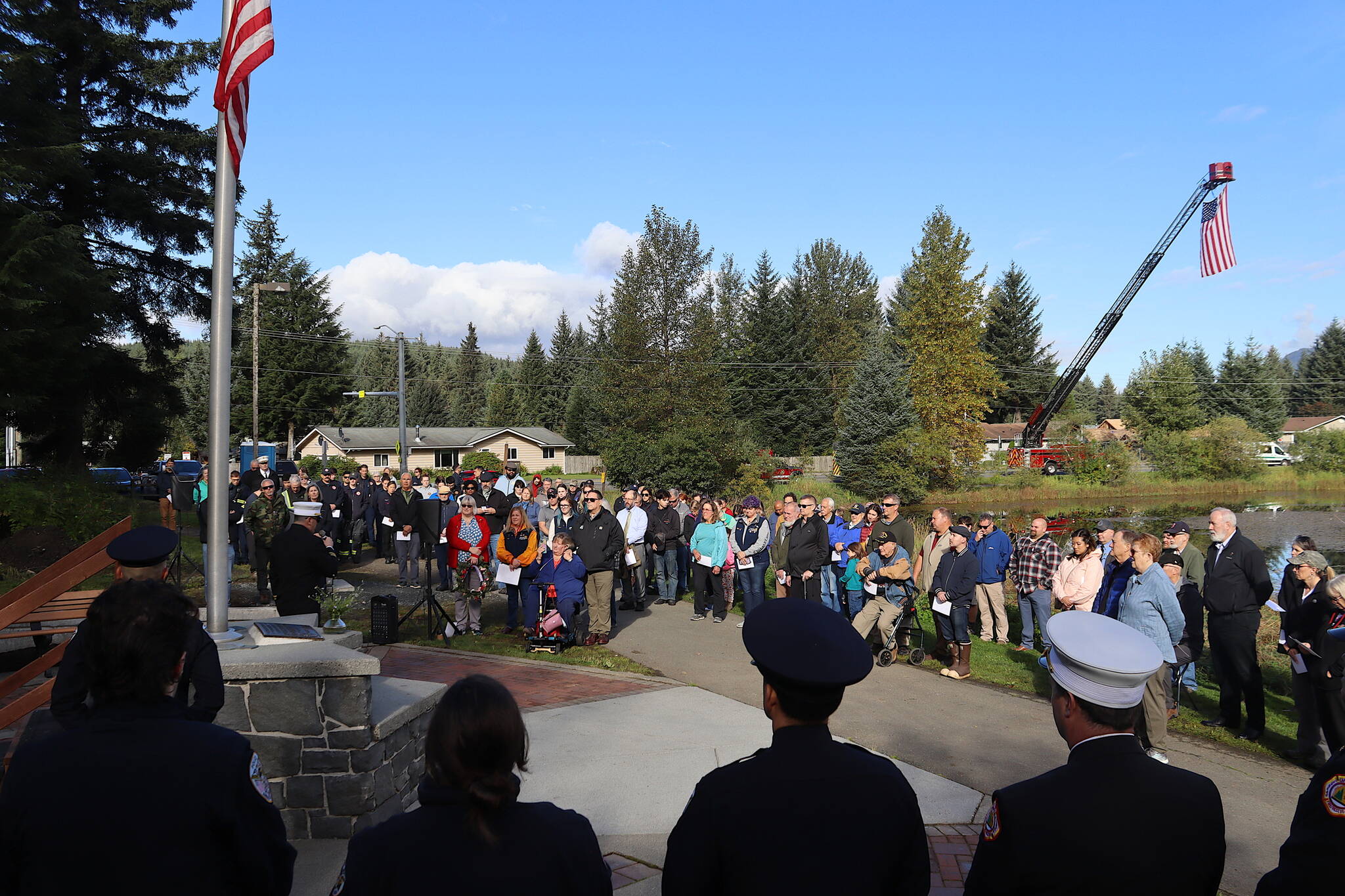 More than 100 local police, firefighters, military personnel and other people gather Wednesday morning at the September 11th Memorial at Riverside Rotary Park to observe the 23rd anniversary of the terrorist attacks that killed 2,996 people. (Mark Sabbatini / Juneau Empire)