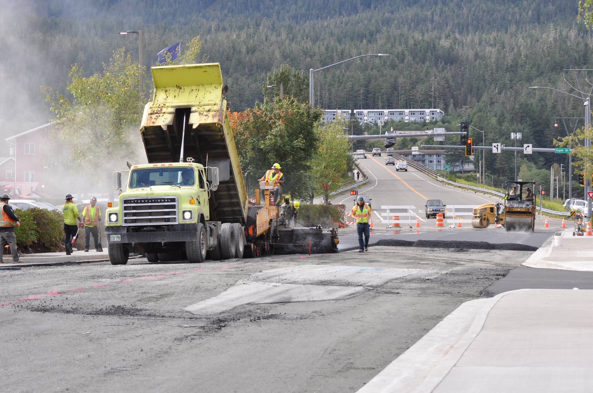 Workers pace the surface of 10th Street near the intersection of Egan Drive on Wednesday. (Laurie Craig / Juneau Empire)