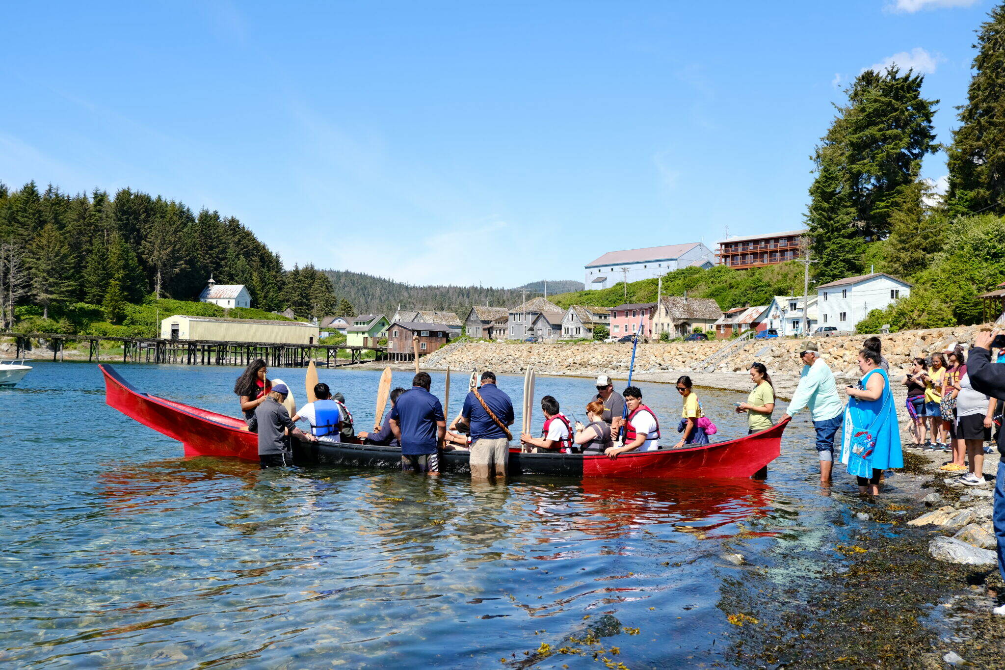 Angoon students prepare to paddle the unity canoe they built with master carver Wayne Price on June 19, 2023. It is the first canoe of its kind since the U.S. Navy bombardment of Angoon in 1882 that destroyed all the village’s canoes. The Navy plans to issue apologies to Kake and Angoon residents in the fall of 2024. (Claire Stremple/Alaska Beacon)