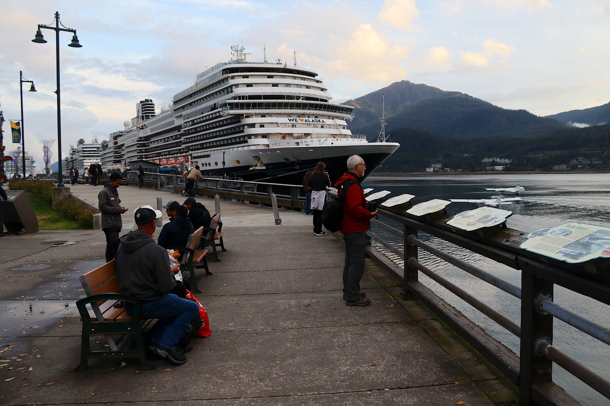 Cruise ship tourists watch floatplanes taxi out in Gastineau Channel on Monday. (Mark Sabbatini / Juneau Empire)