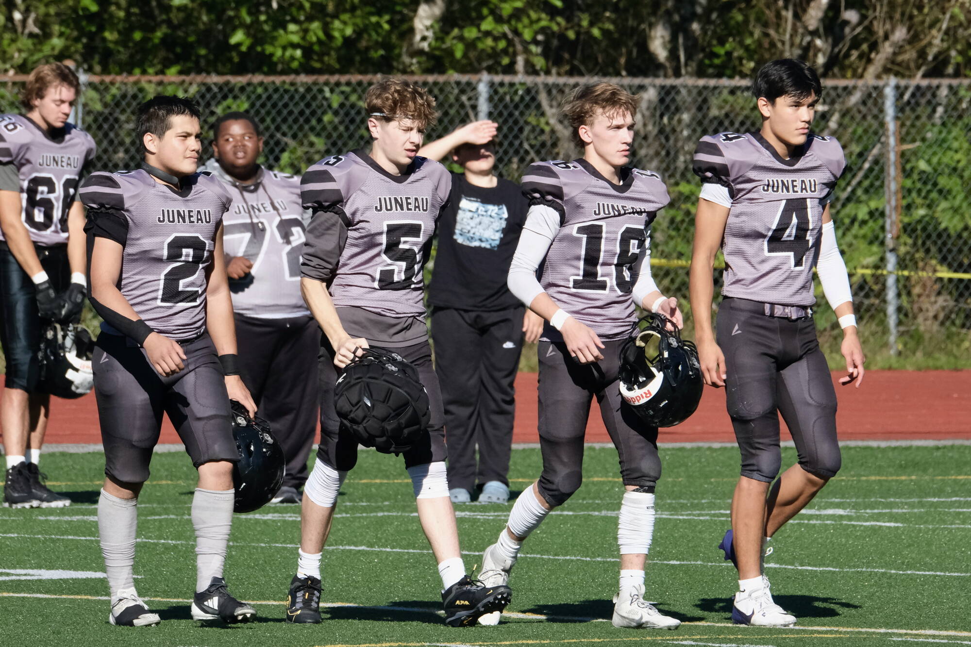 Juneau Huskies senior captains Hayden Aube (2), Sage Schultz (5), Caleb Ziegenfuss (16) and Jayden Johnson (4) approach the center of Adair-Kennedy Memorial Park for the coin toss of last weekend’s game against West Anchorage. (Klas Stolpe/For the Juneau Empire)