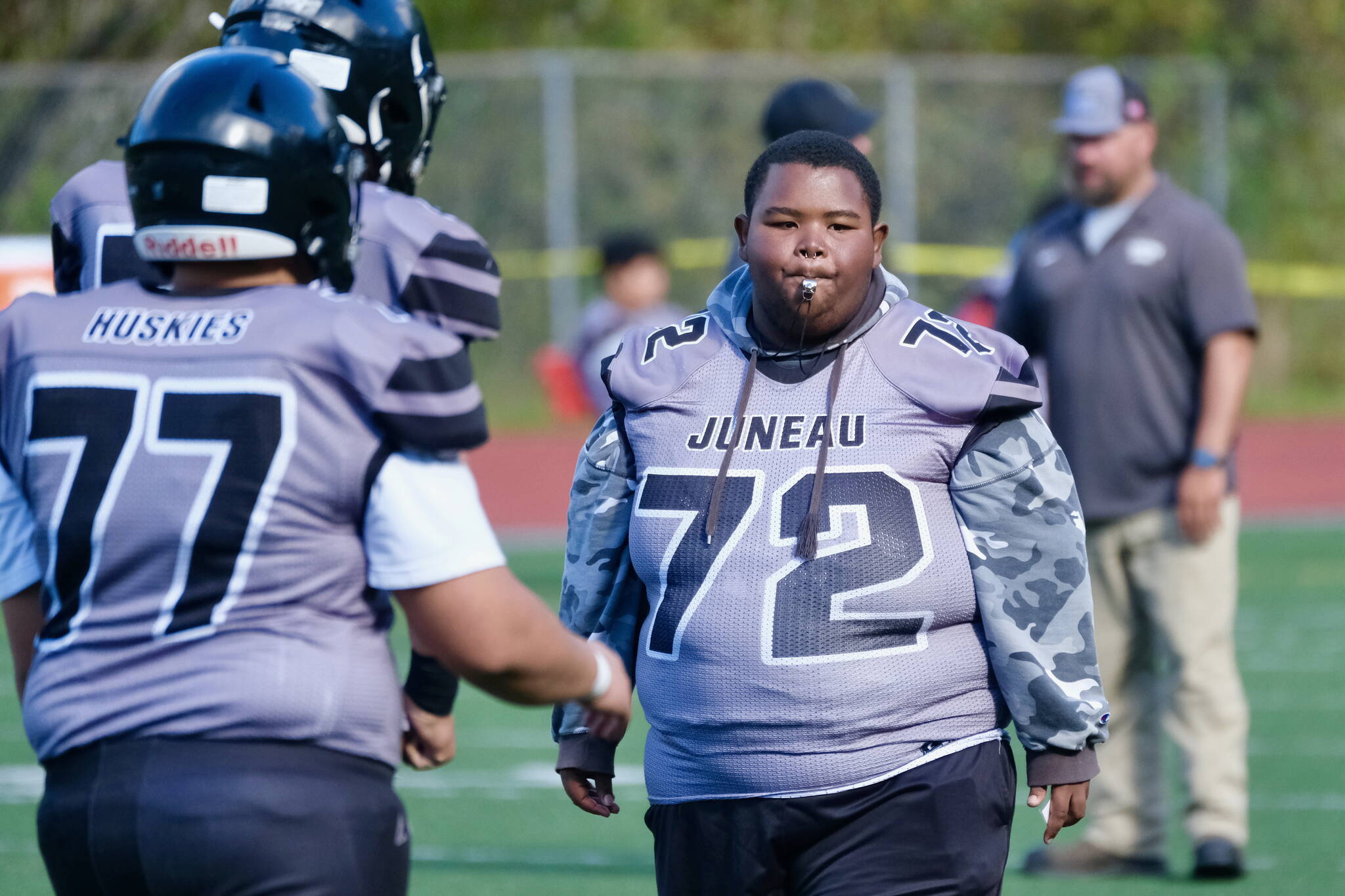 Juneau-Douglas High School: Yadaa.at Kalé freshman assistant coach and manager Jaasyah Crowley (72) directs varsity warmups before the Juneau Huskies’ game against West Anchorage High School last Saturday at Adair-Kennedy Memorial Park. (Klas Stolpe / For the Juneau Empire)