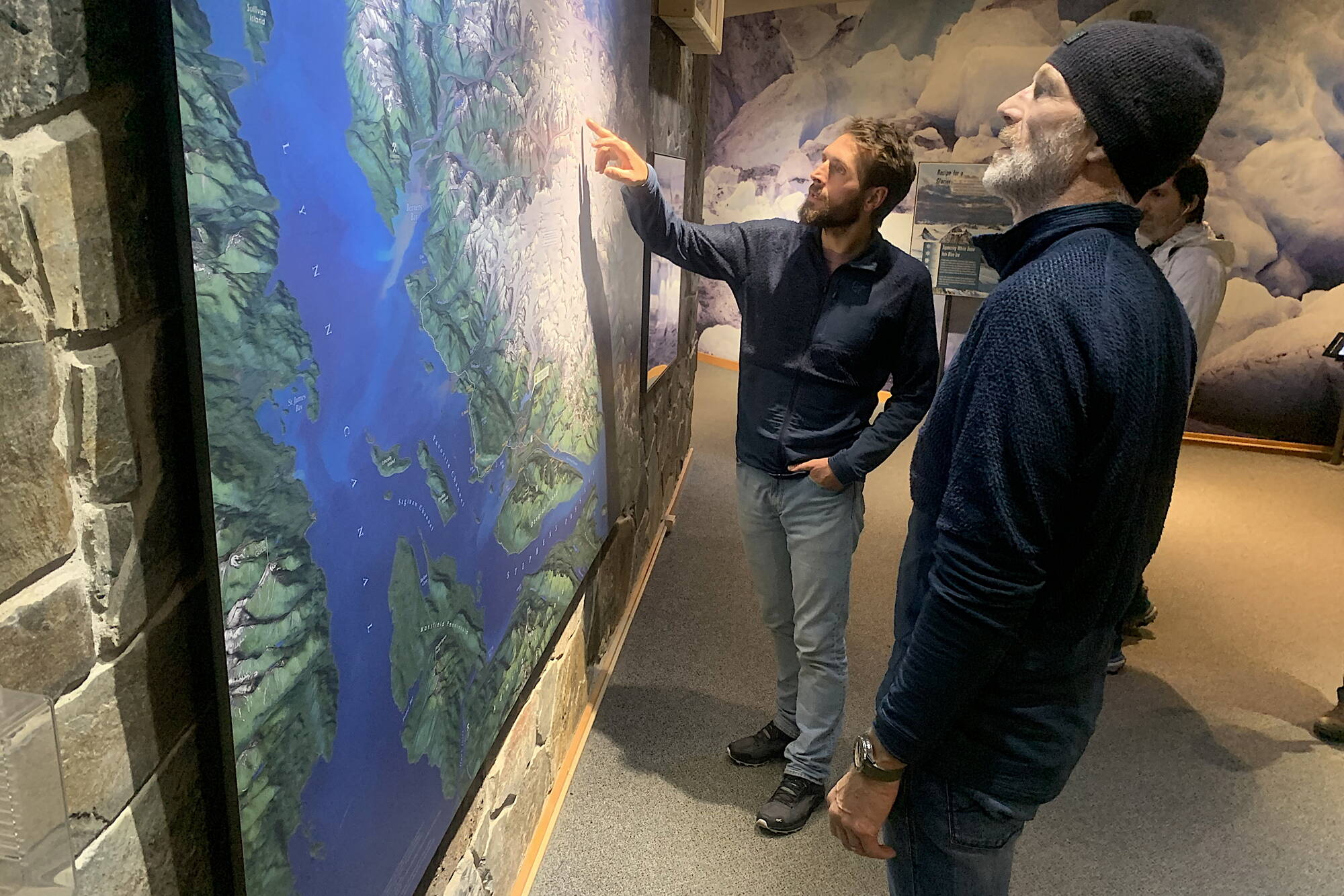 Vincent Colliard (left) and Børge Ousland examine a map of the Juneau Icefield at the Mendenhall Glacier Visitor Center on Friday night before giving a presentation about their planned crossing of the icefield. (Mark Sabbatini / Juneau Empire)