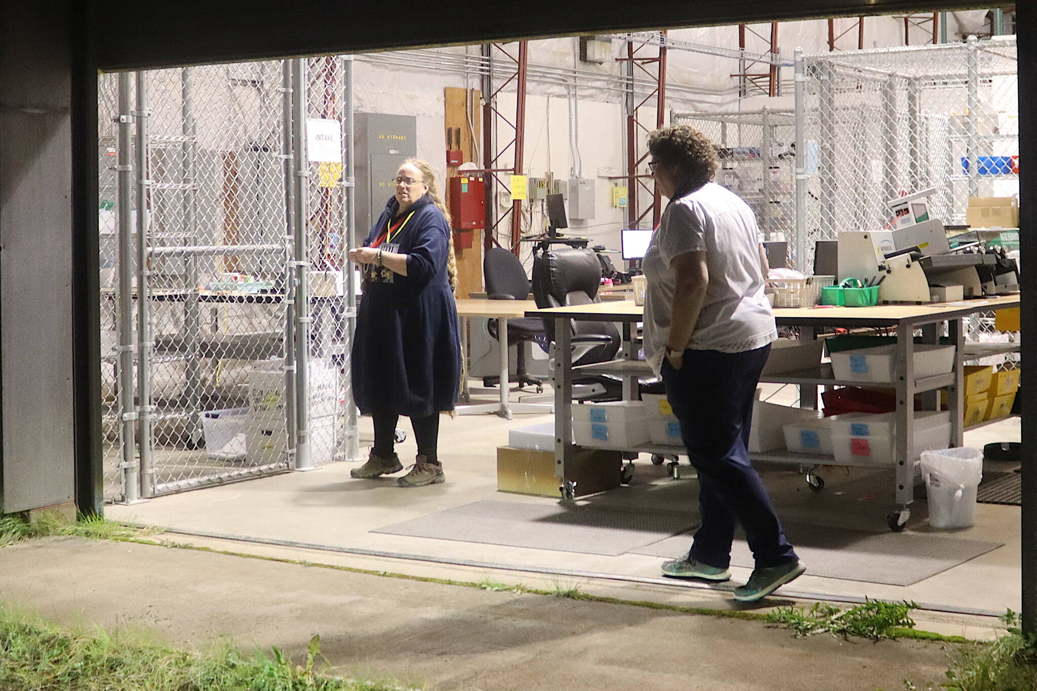 Juneau Municipal Clerk Beth McEwen (right) and Deputy Clerk Diane Cathcart await the arrival of election materials as early ballots are counted at the Thane Ballot Processing Center on Tuesday night. (Mark Sabbatini / Juneau Empire)