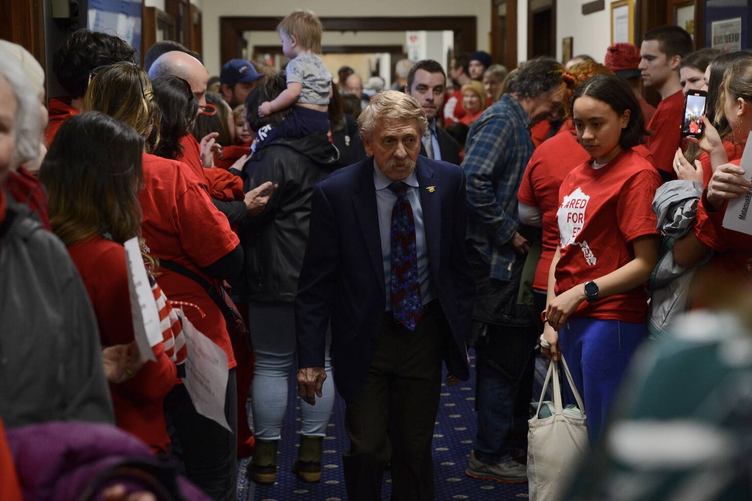 Rep. Laddie Shaw, R-Anchorage, is surrounded by education advocates as he enters the House chambers before a veto override vote on Senate Bill 140 on Monday, March 18, 2024. Shaw voted no on the override, which failed by a single vote. (James Brooks/Alaska Beacon)