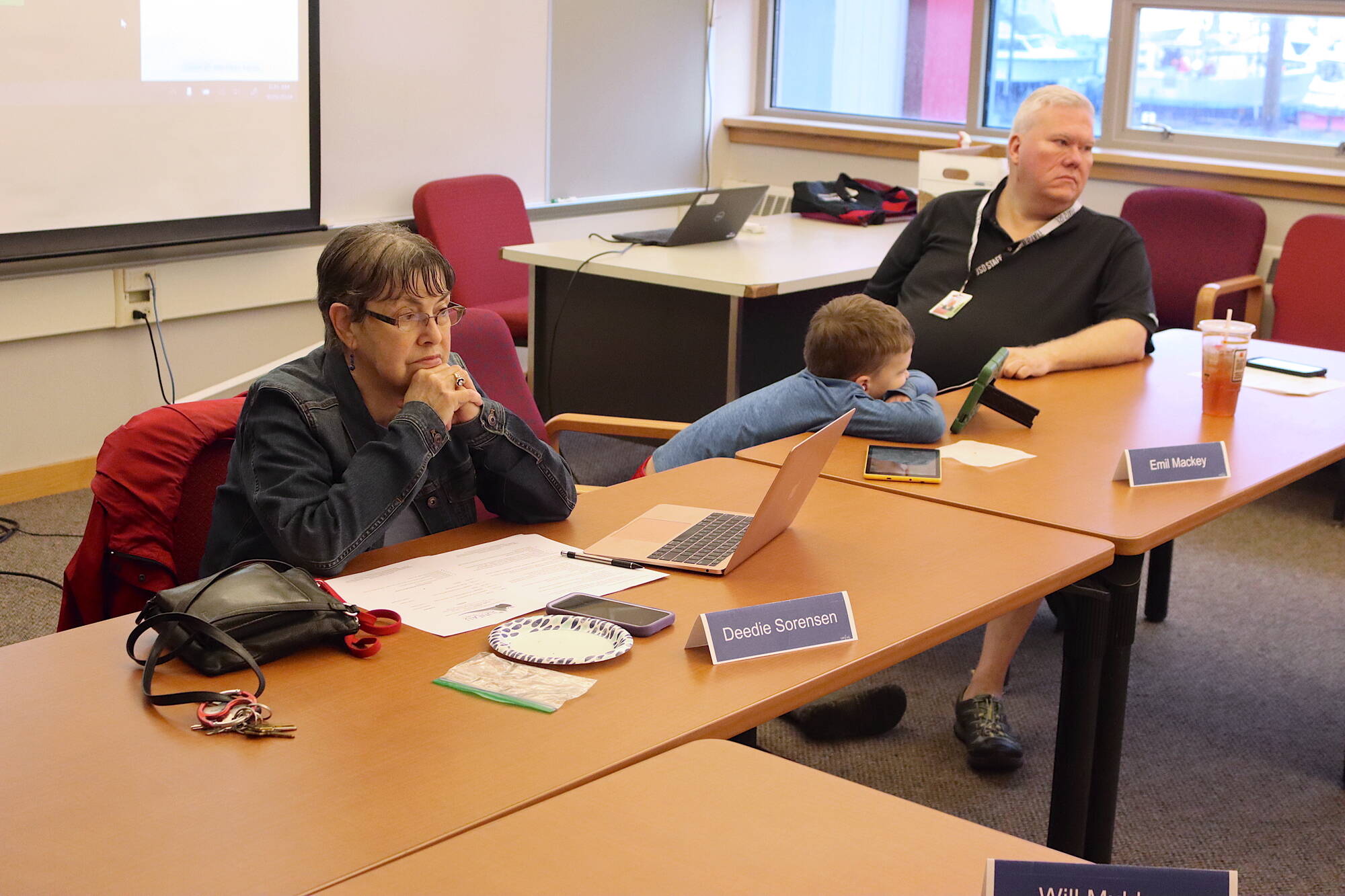 Juneau Board of Education President Deedie Sorensen (left) and Vice President Emil Mackey (right), with his son Emil Mackey IV between them, listen to a presentation during a school board retreat at Juneau-Douglas High School: Yadaa.at Kalé on Saturday, Sept 28. Recall votes for both board members are failing in the initial vote tally in this year’s municipal election. (Mark Sabbatini / Juneau Empire)